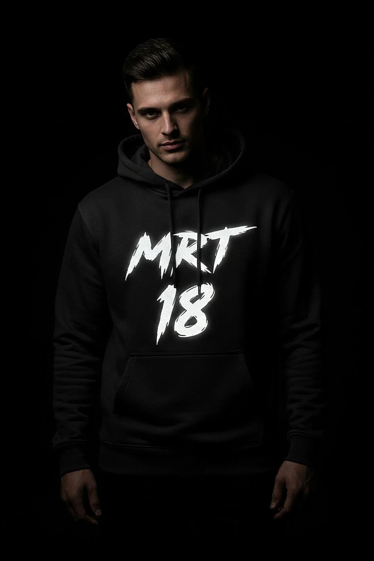 Black hoodie front view with matte white MRT 18 graffiti lettering on chest in daylight