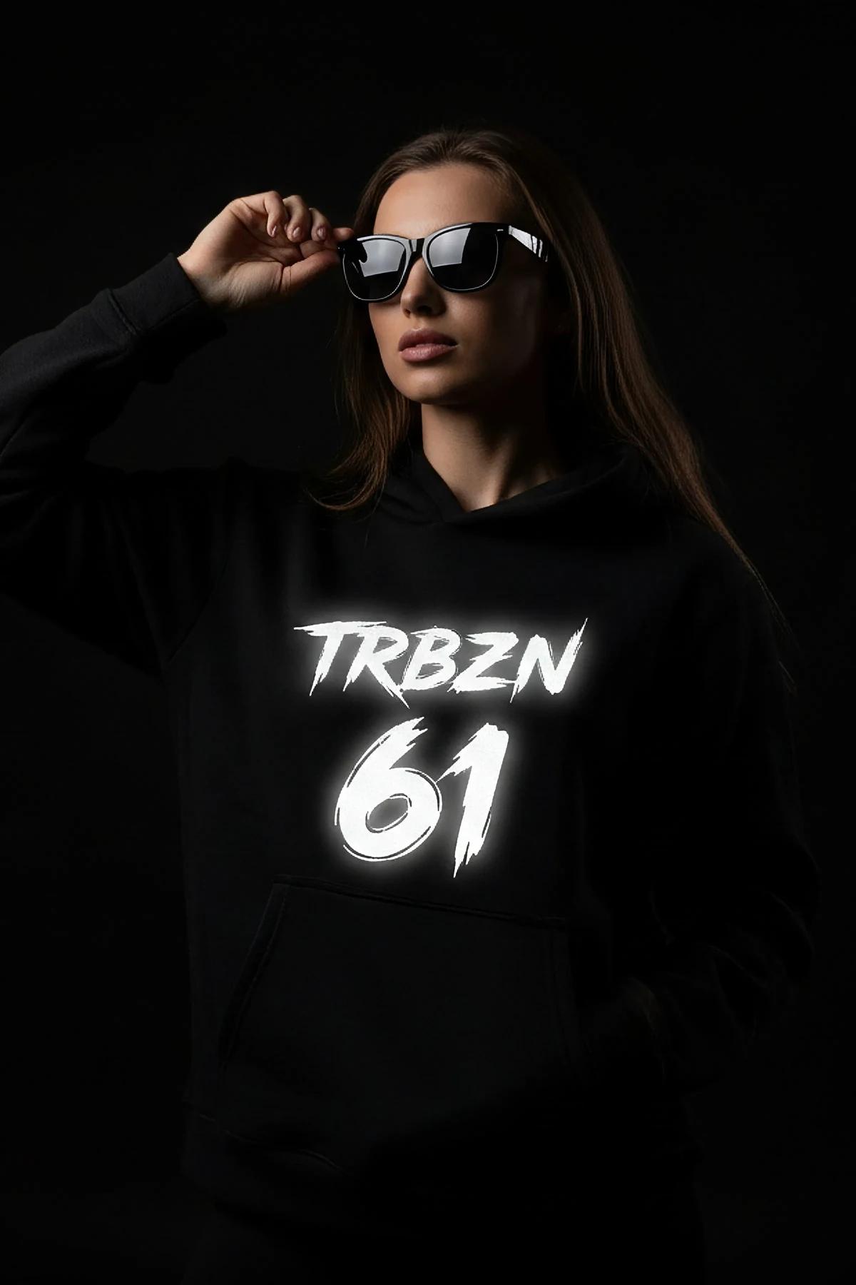 Reflective black hooded sweatshirt with large TRBZN 61 brushstroke chest print glowing white under direct light