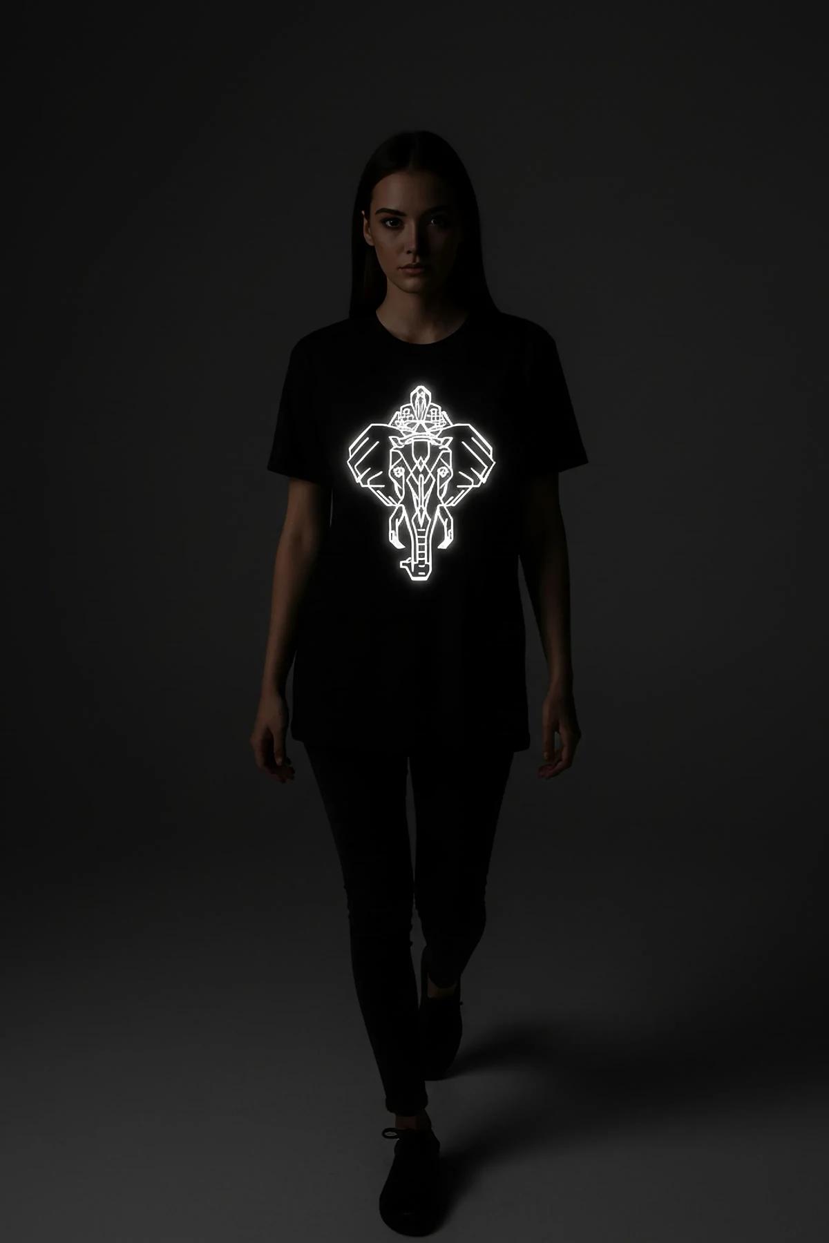 Black oversize t-shirt with bright white reflective geometric elephant polygon print on front chest, worn in dark setting