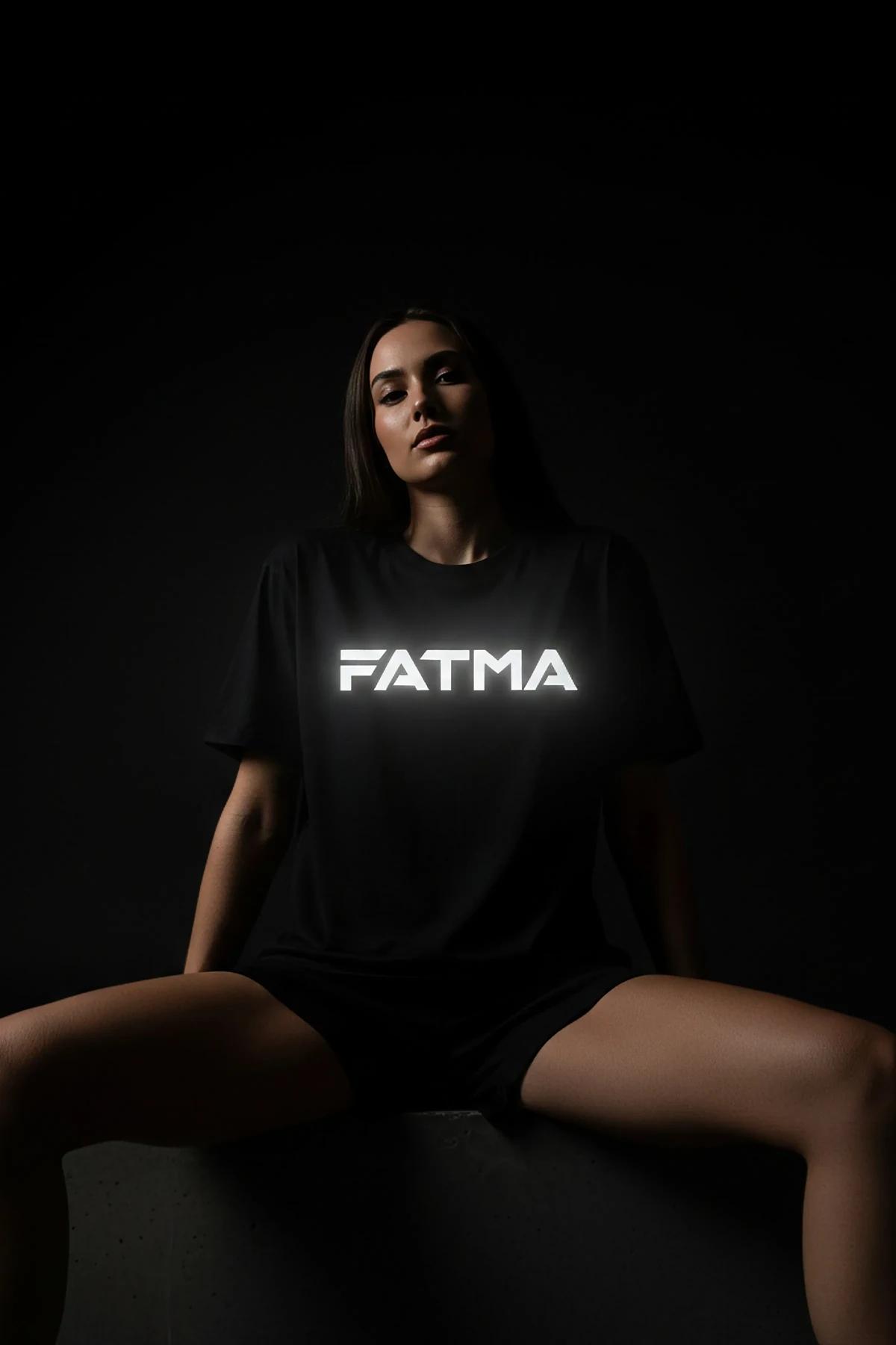 Detail of retro-reflective white name print on black jersey fabric, approximately 20 cm wide