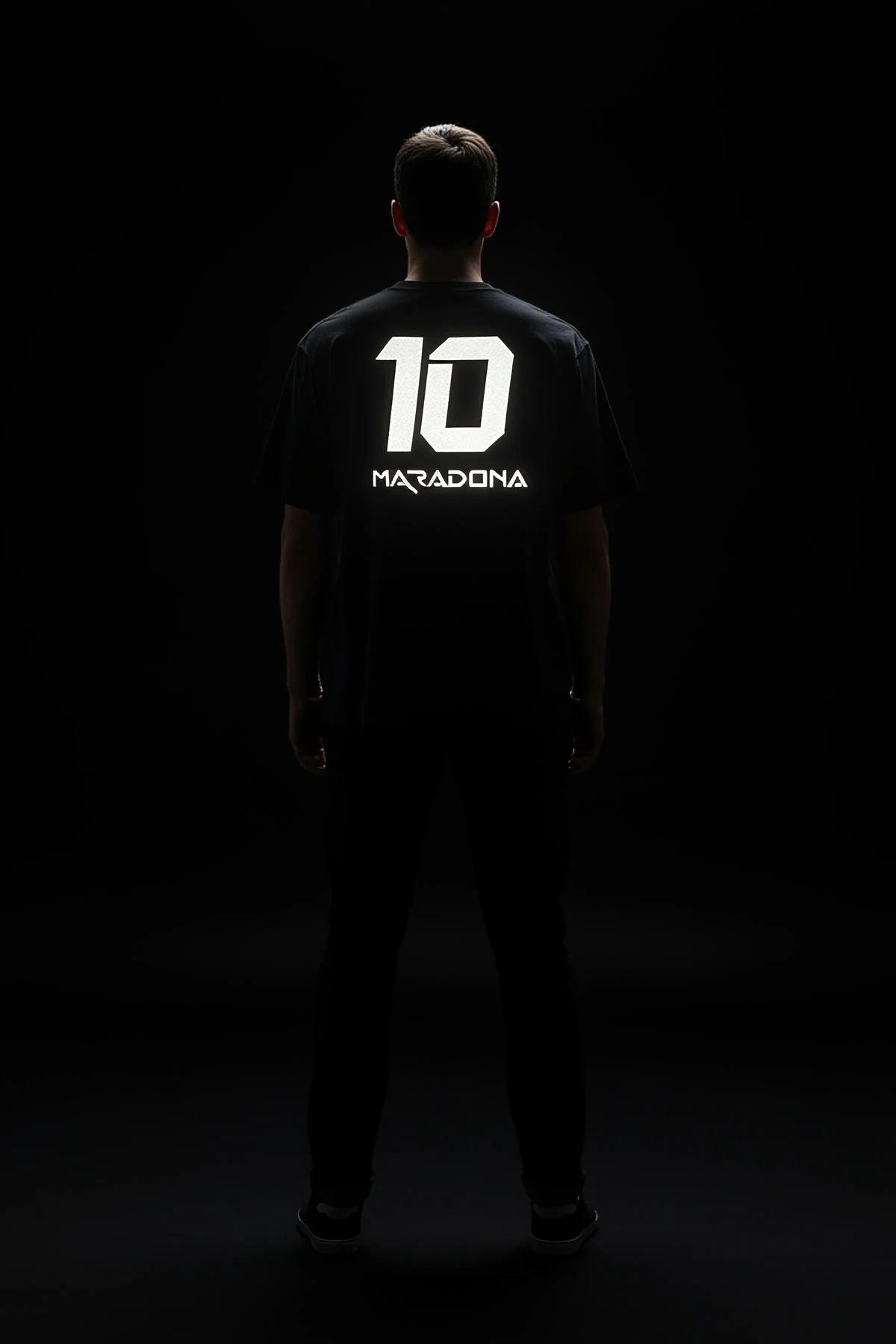 black oversize t-shirt back view with bright white reflective Maradona 10 print illuminated under direct light