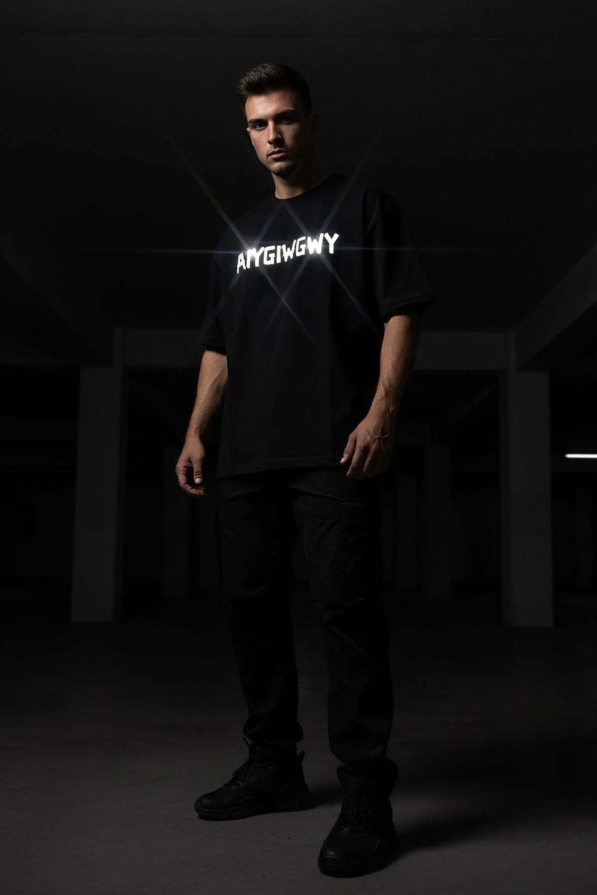 close-up of retroreflective AIYGIWGWY block lettering on black cotton-blend jersey t-shirt chest