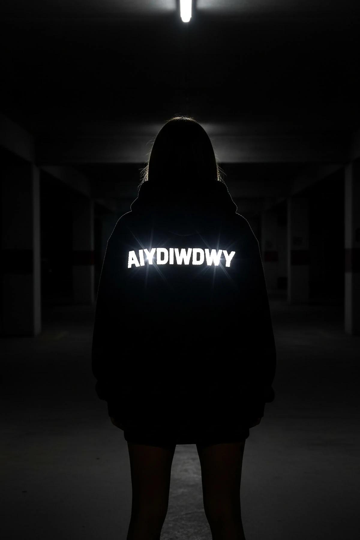 Full-length flat-lay of black oversized hoodie with reflective front and back graphic print
