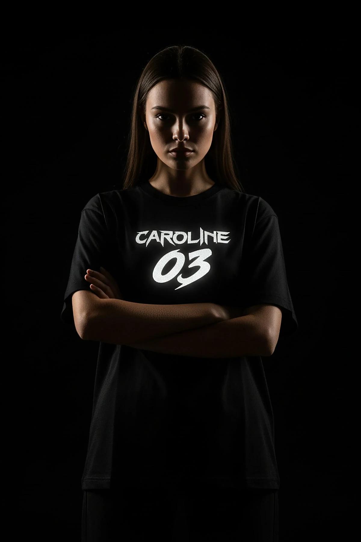 black oversize t-shirt with reflective CAROLINE 03 front chest print glowing under flash light