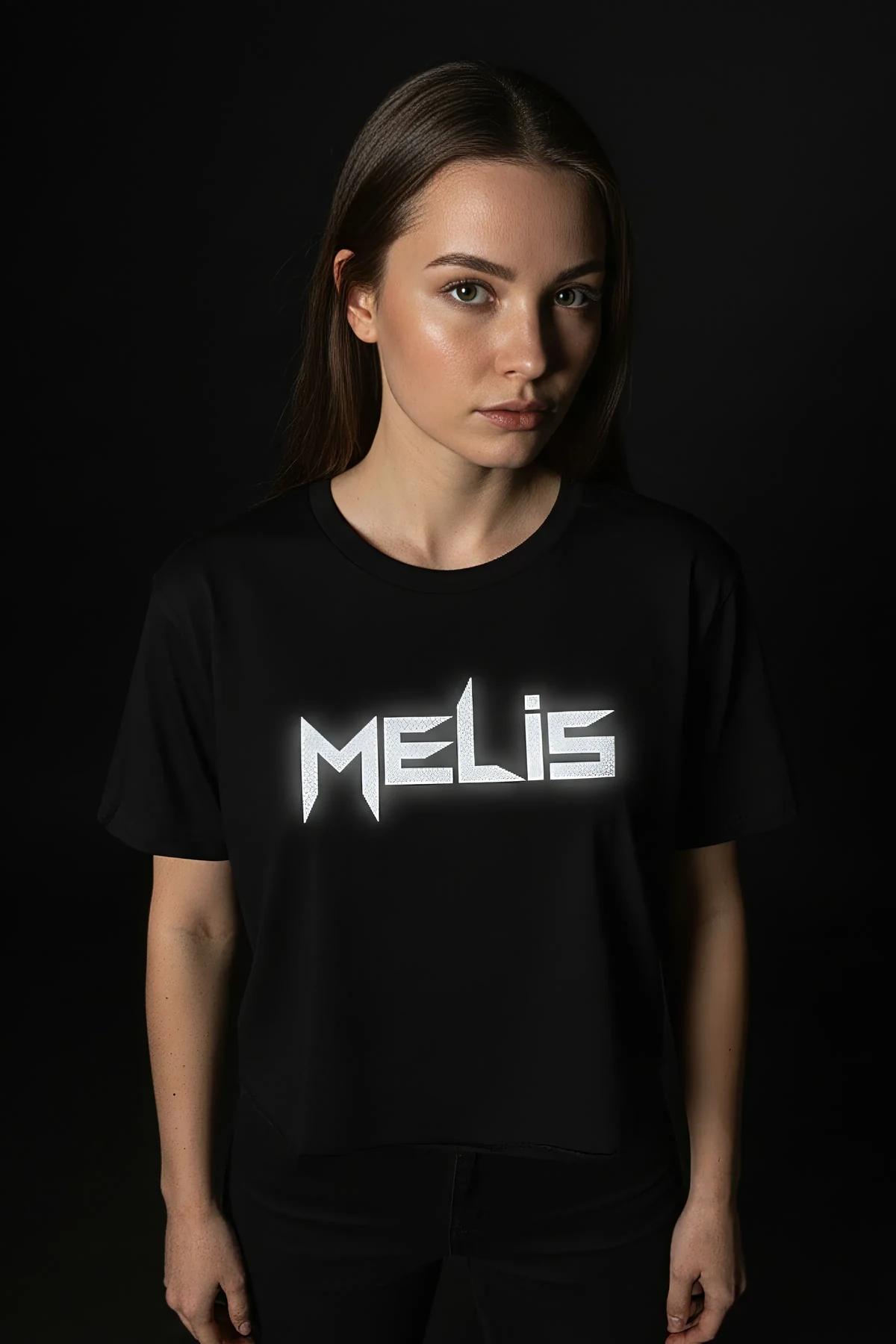 Black crop t-shirt with MELIS reflective angular name print glowing silver-white on chest, worn by young woman