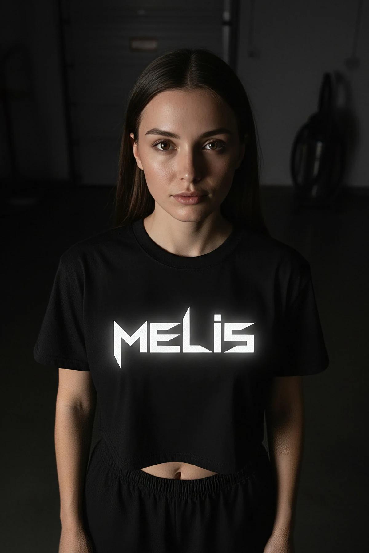 Close-up of MELIS reflective heat-transfer name print on black cotton jersey crop tee