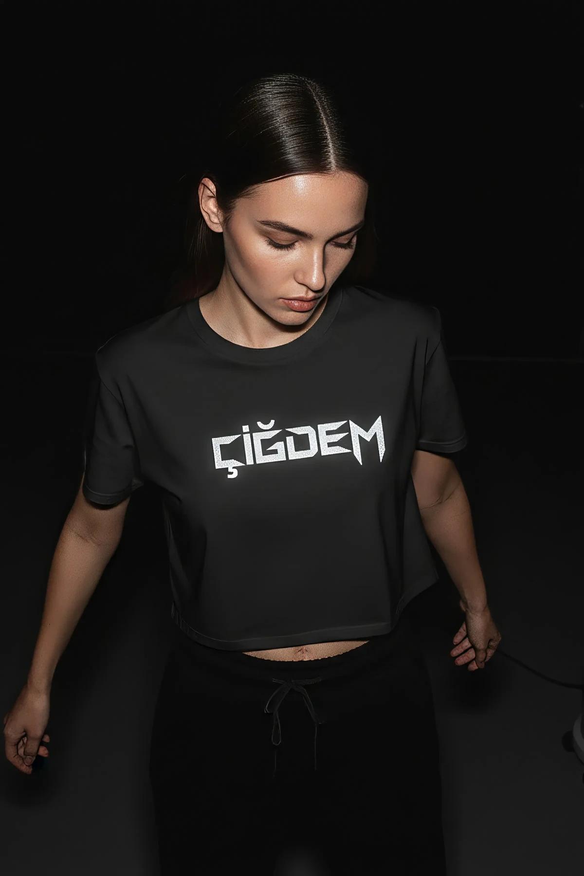 Black cotton crop t-shirt with bold white reflective CIGDEM name print across full chest, worn by female model
