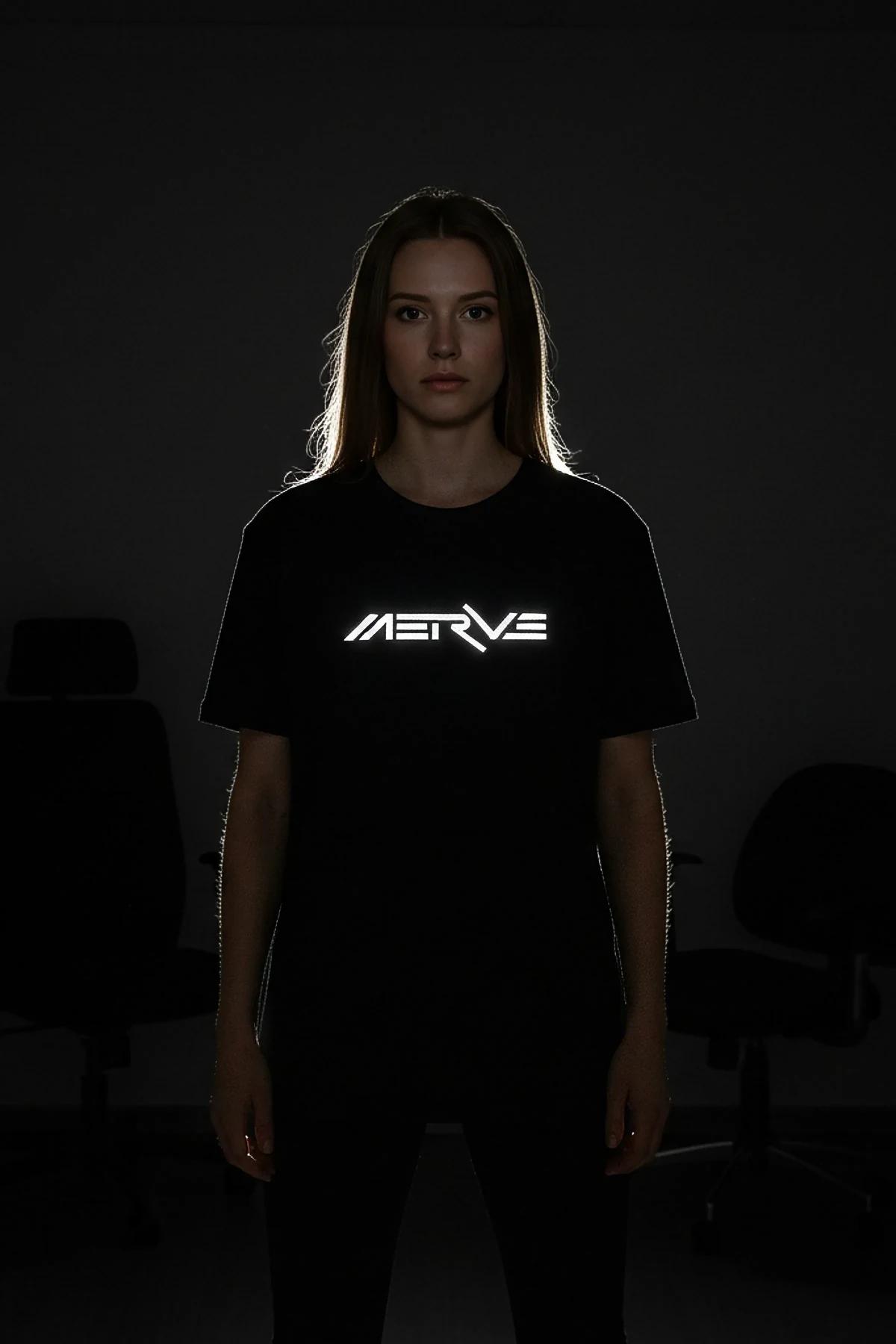Black oversize t-shirt with bright white reflective futuristic-font MERVE print glowing on chest in low light