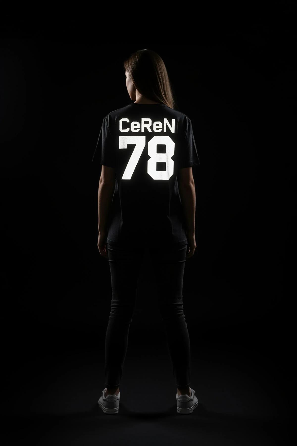 Oversize black t-shirt back view with bold reflective CeReN 78 collegiate print glowing under camera flash