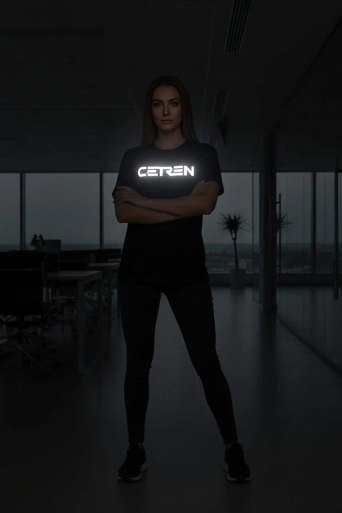 black oversize t-shirt with bright white reflective CEREN chest print glowing in low light, woman wearing relaxed fit crew ne
