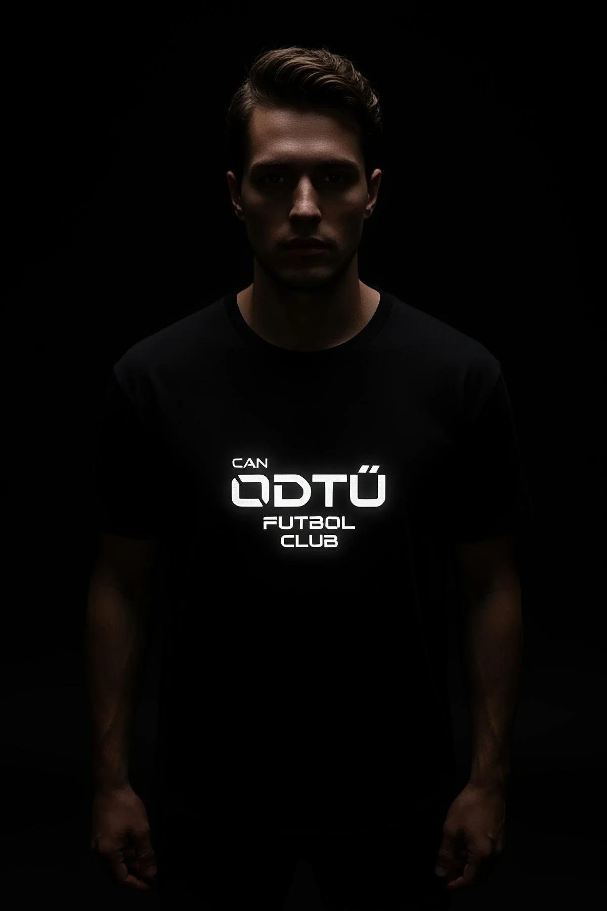 Black oversized t-shirt with reflective CAN ODTU FUTBOL CLUB front print glowing white under direct light