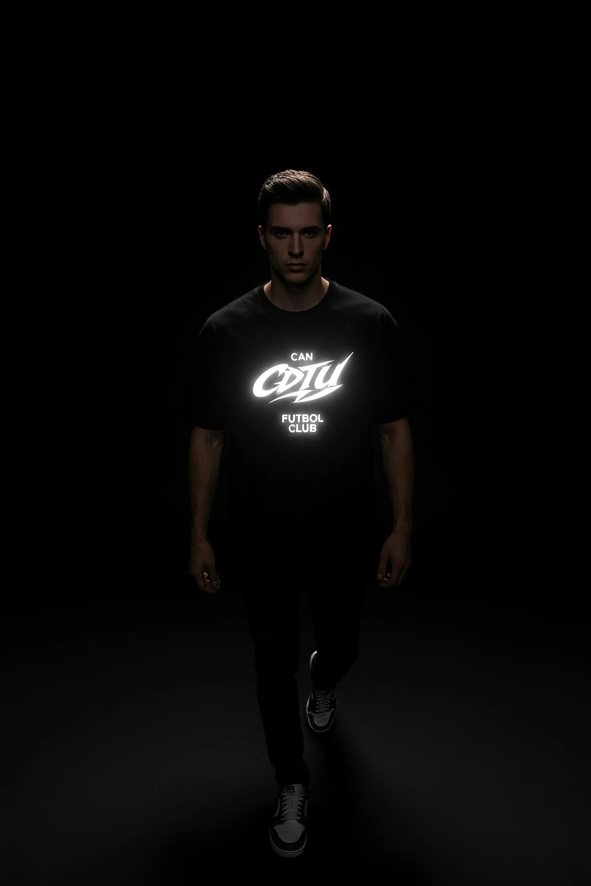 Close-up of retroreflective white typographic chest print on black combed cotton t-shirt