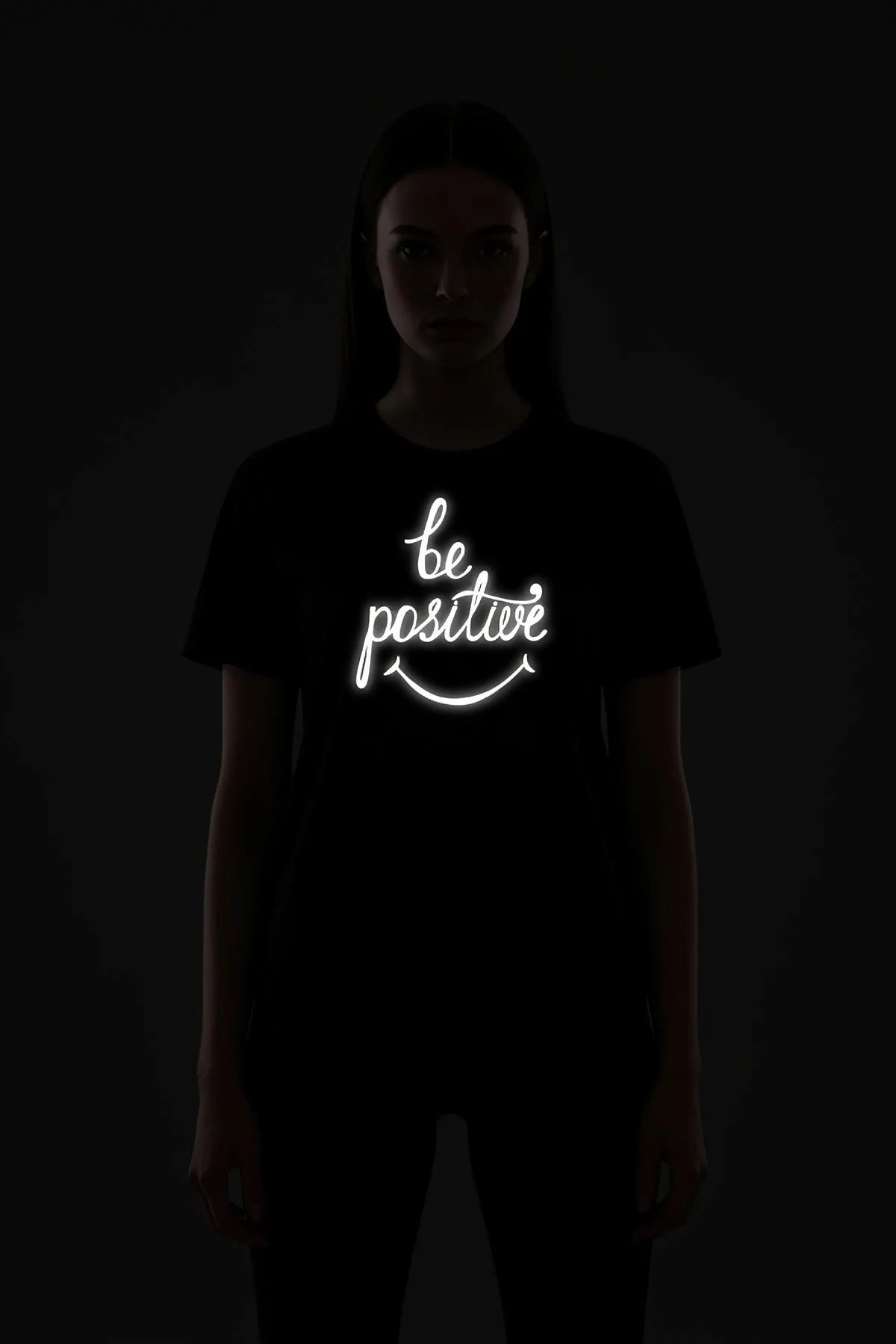 Oversize black t-shirt drop-shoulder silhouette with reflective front print in daylight