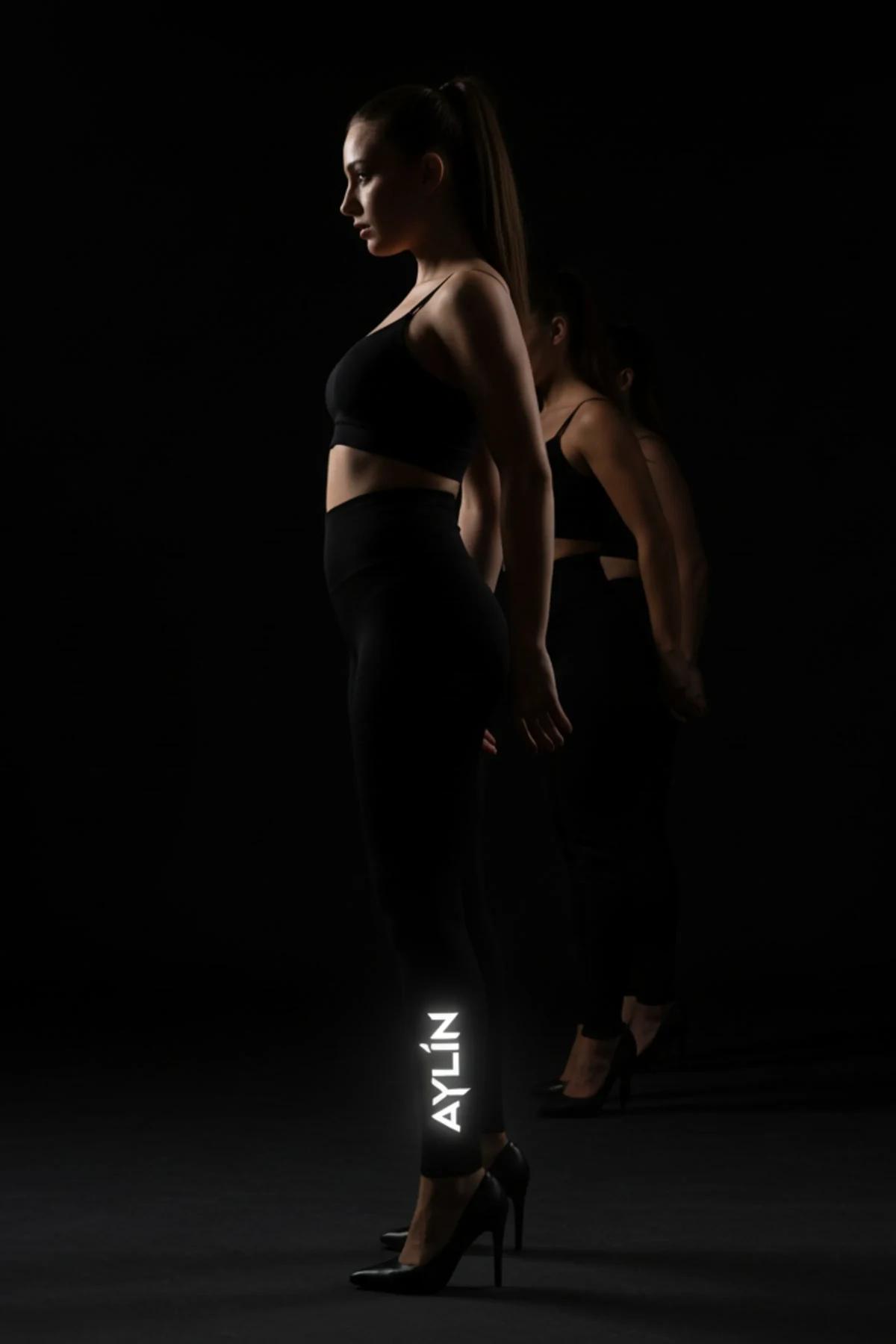 Black reflective custom name print leggings with glowing AYLIN text on outer calf, high-rise waistband, matte stretch knit