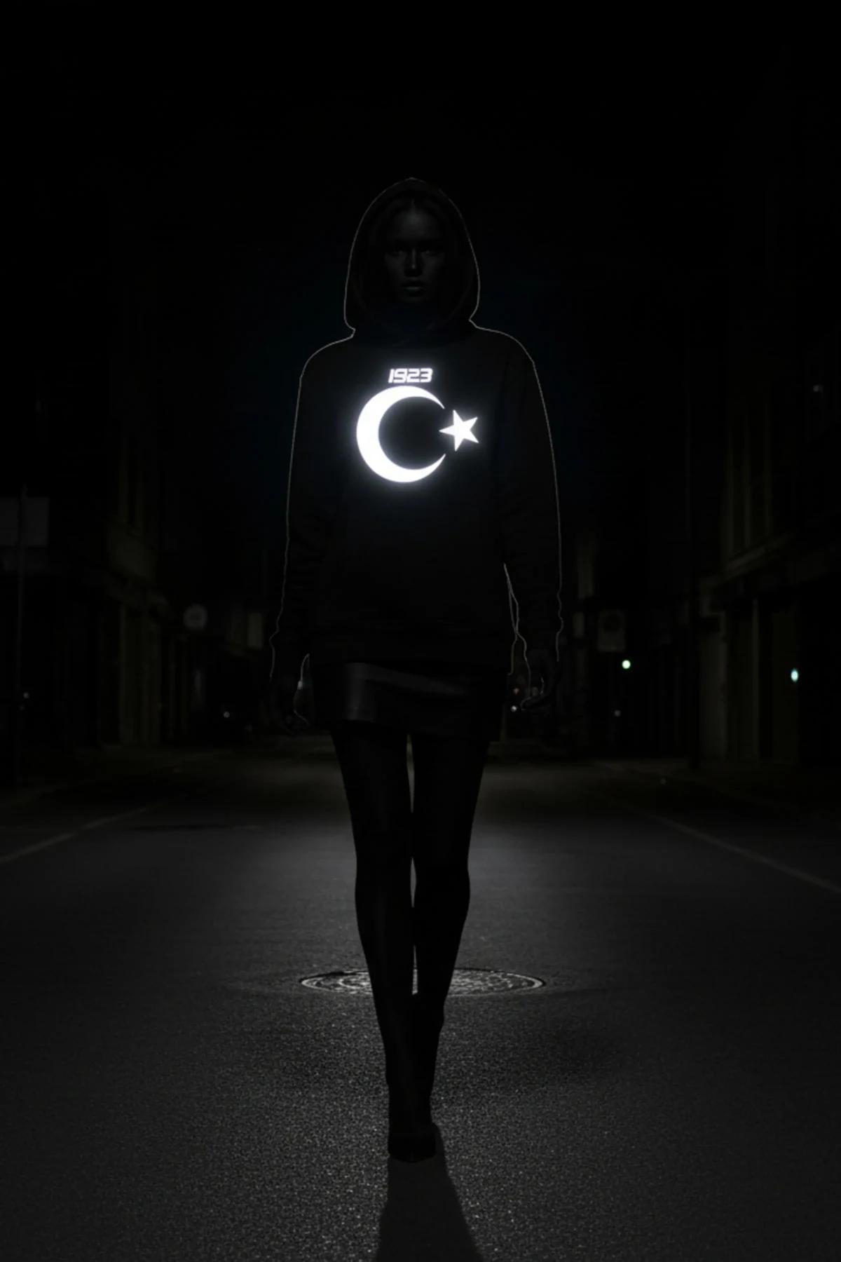 reflective 1923 crescent star black hooded sweatshirt front print glowing at night on dark street