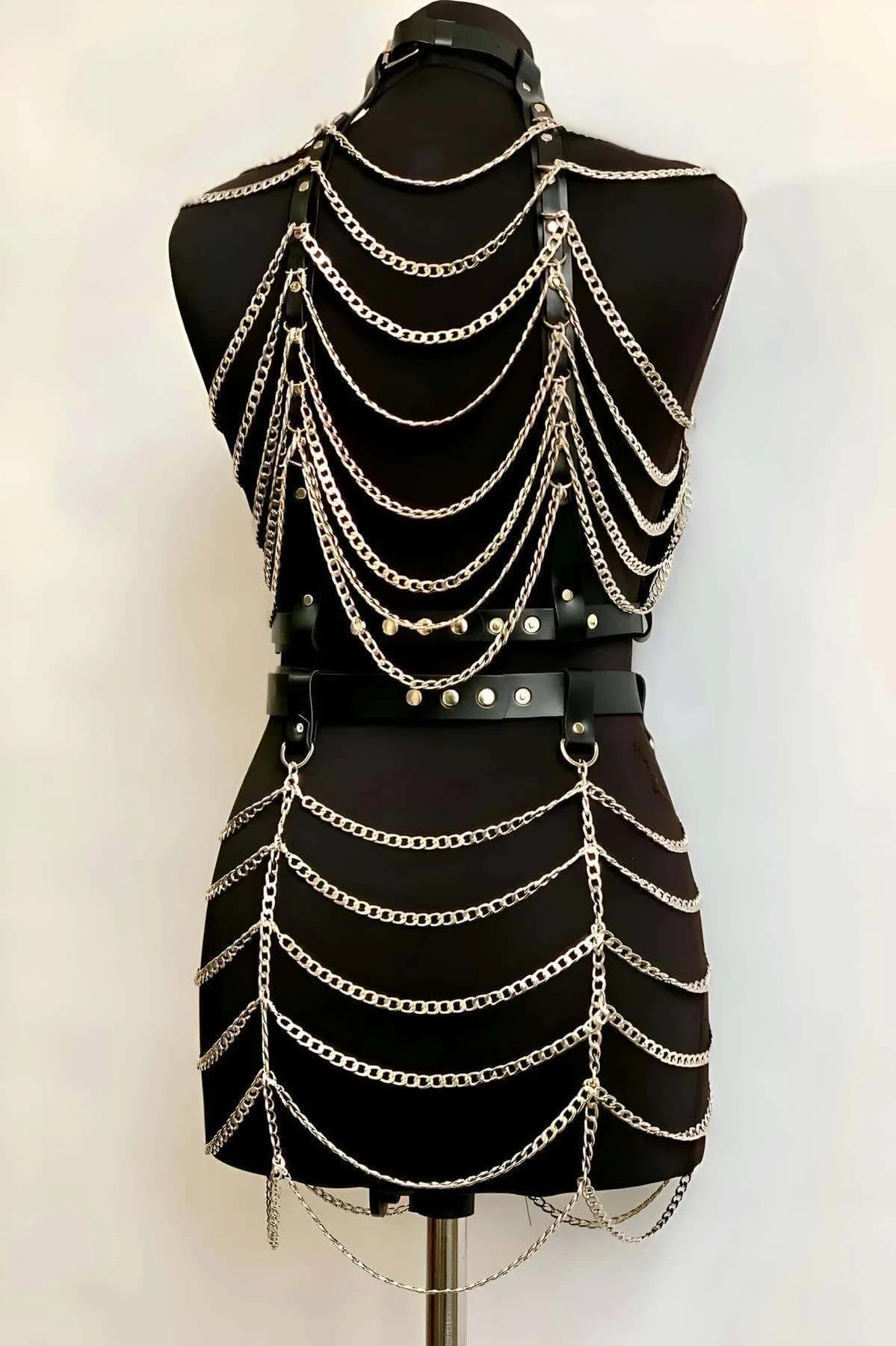 Side angle of black PU leather harness top showing adjustable strap buckles and layered silver chains