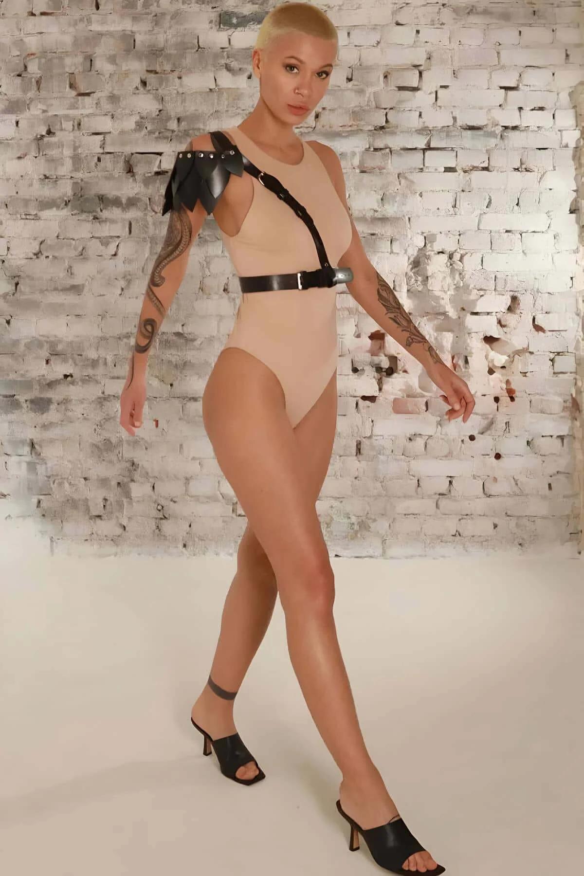 Diagonal chest strap detail connecting shoulder epaulette to waist belt on black harness