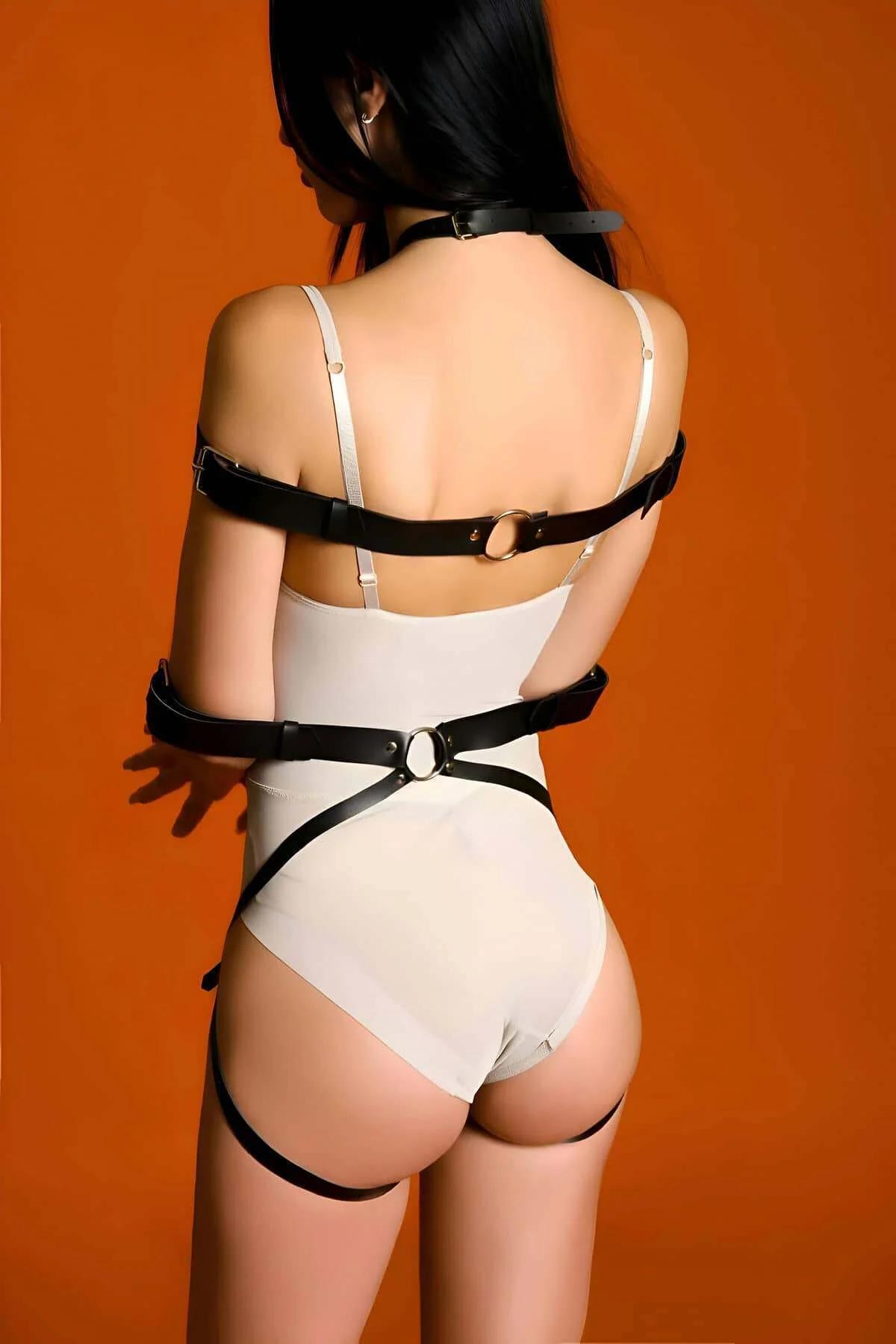 Smooth black faux leather neck collar and chest cross strap with central silver O-ring close-up
