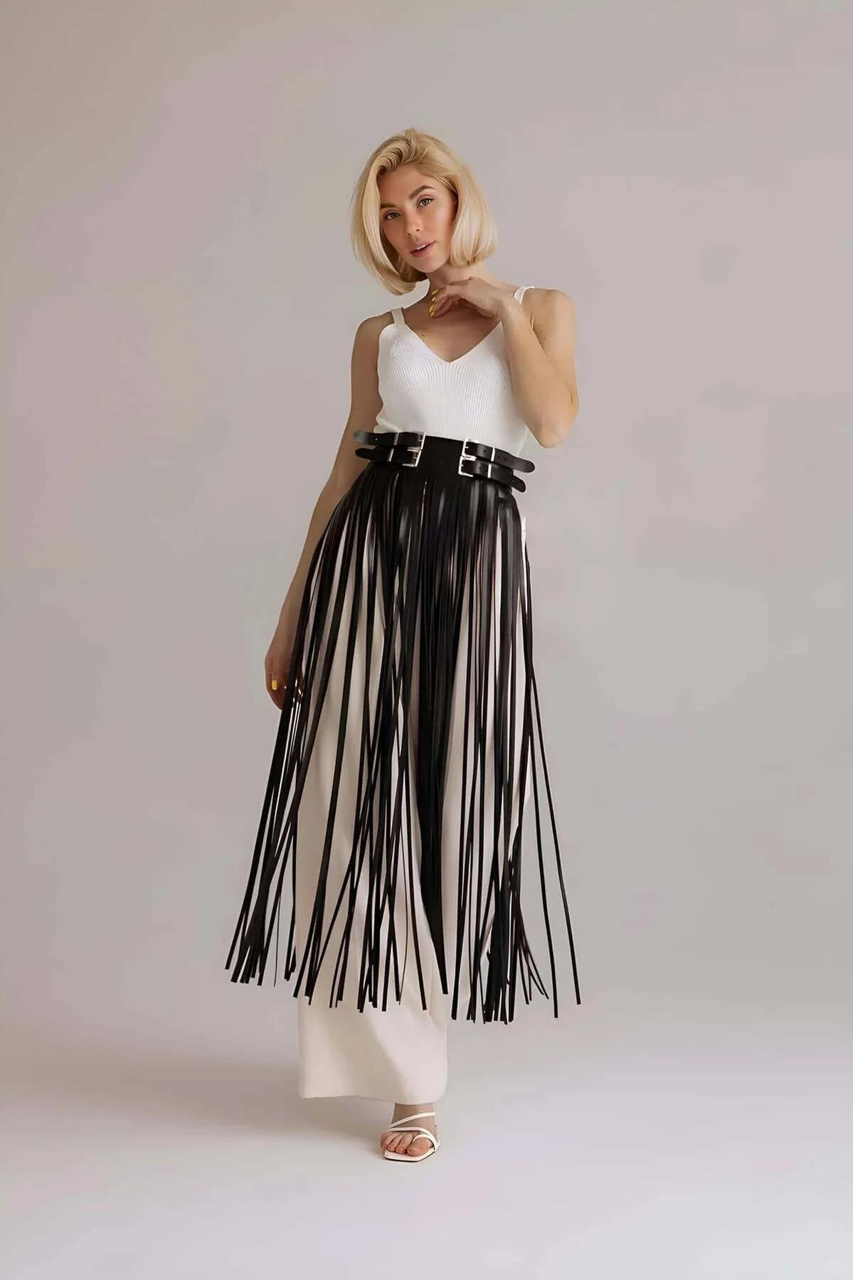 Side angle of black vegan leather fringe skirt overlay showing strap drape and waist fit