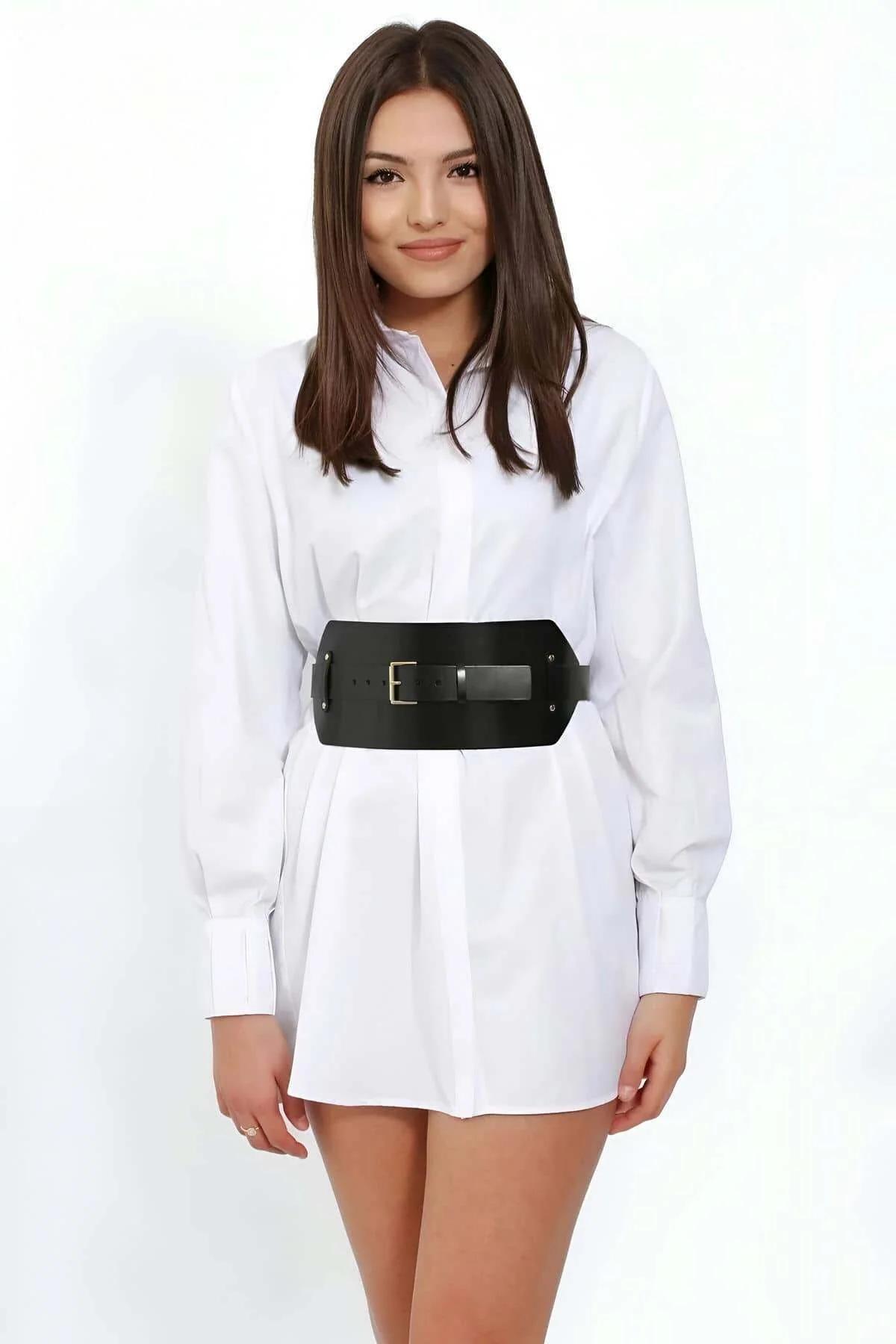 Close-up of gold-tone square buckle and stud rivet detail on black cinch belt
