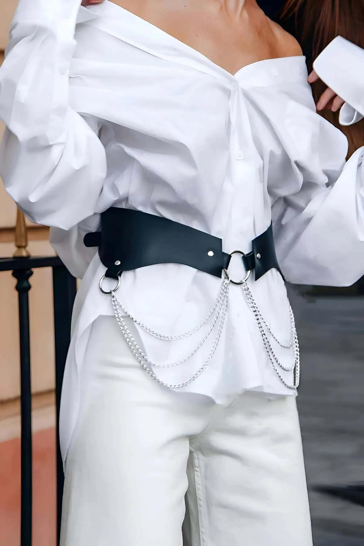 Close-up of silver O-ring and rivet detail on black wide waist harness belt