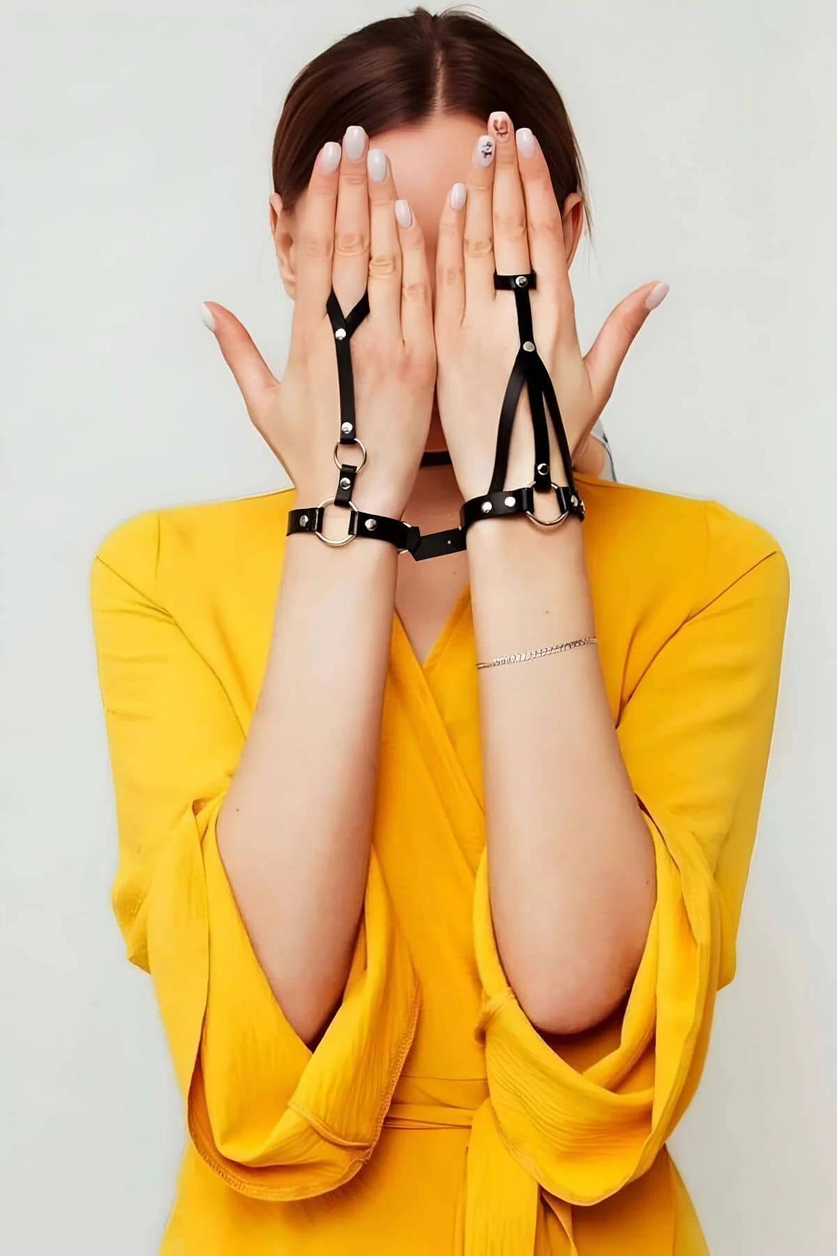 Back-of-hand view showing thin black faux leather straps splitting into two finger loops
