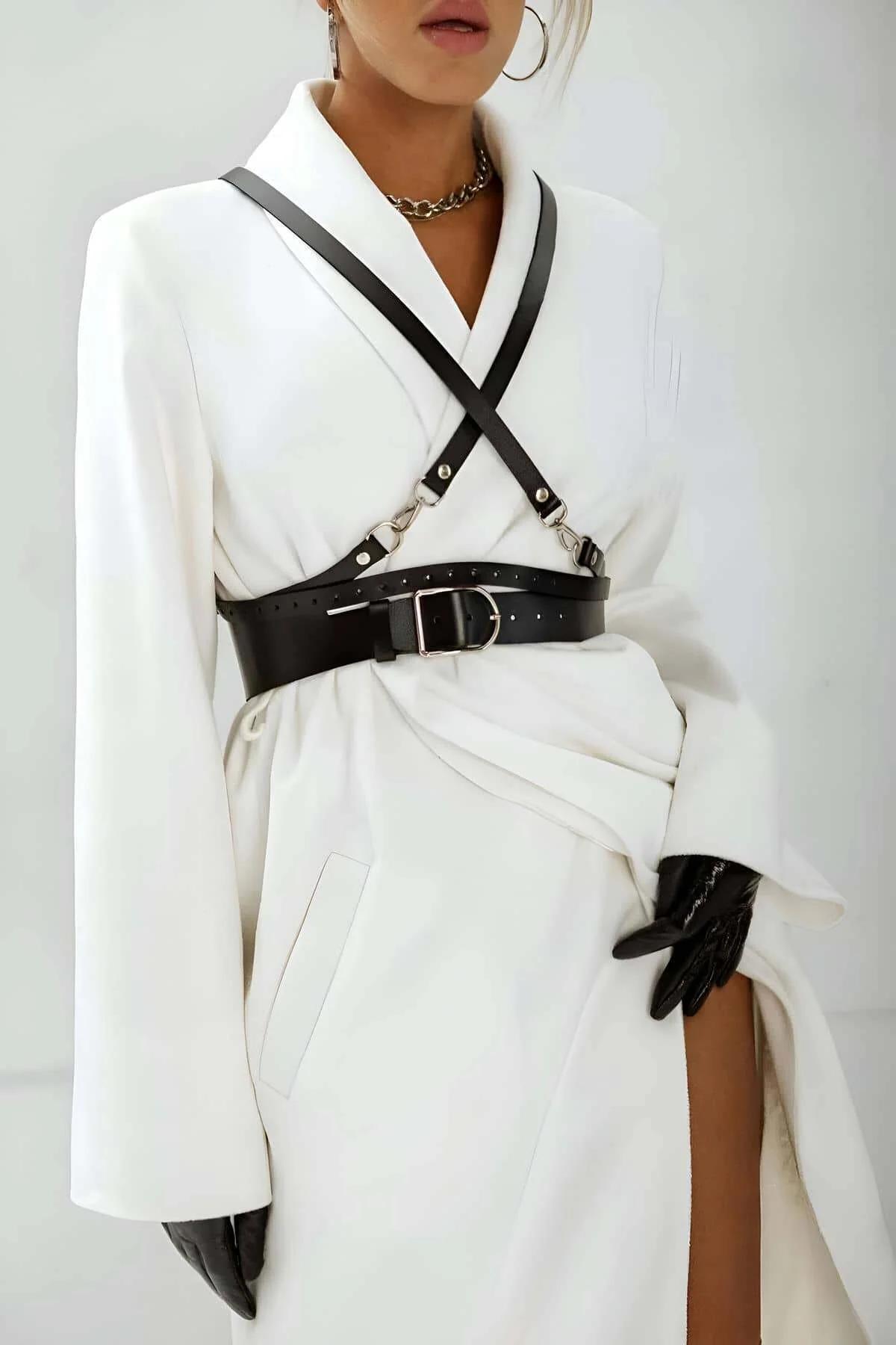Black adjustable harness belt with slim trailing strap falling to mid-thigh over fitted outfit