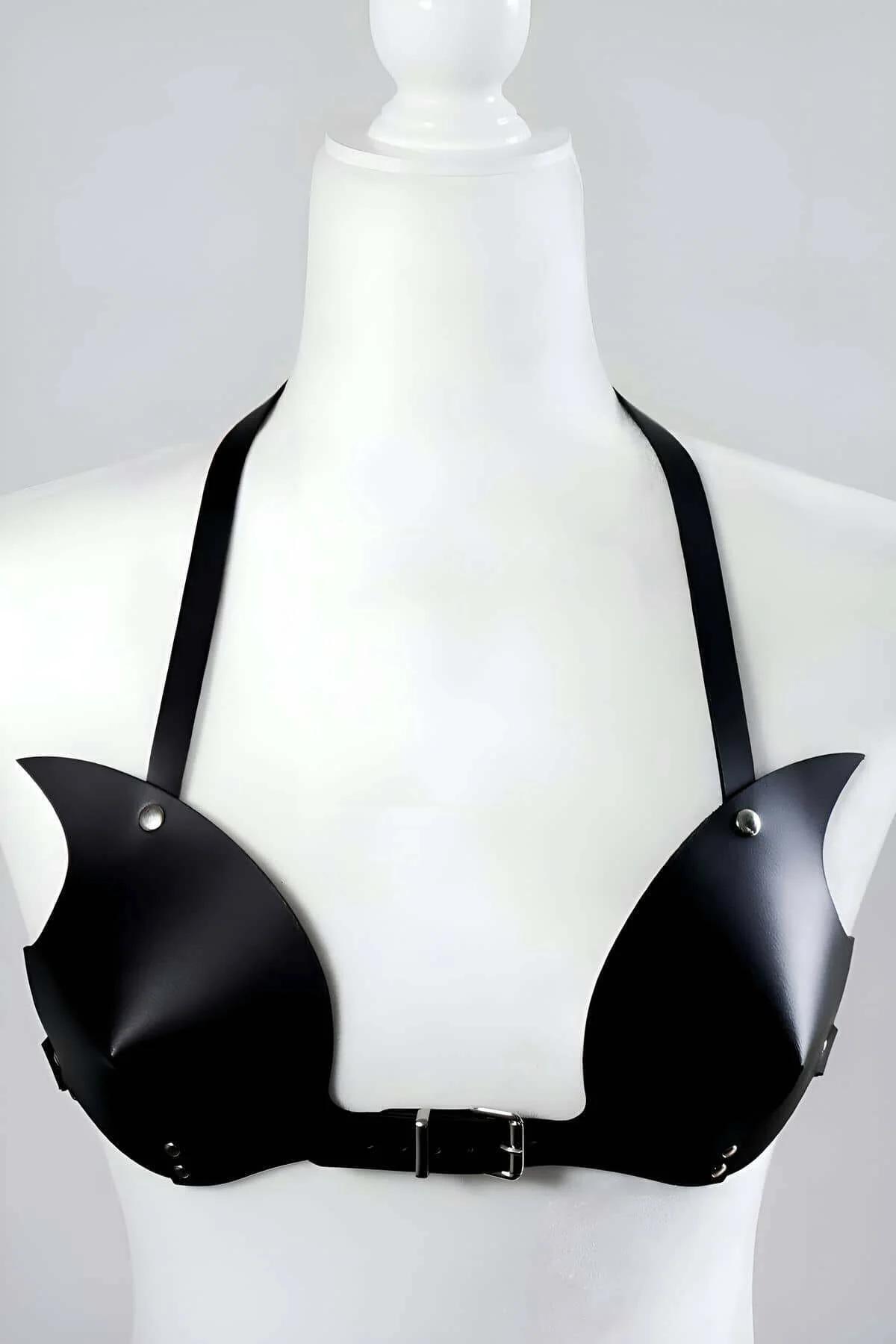 Close-up of black faux leather molded cup bra harness showing silver stud accents and center buckle detail