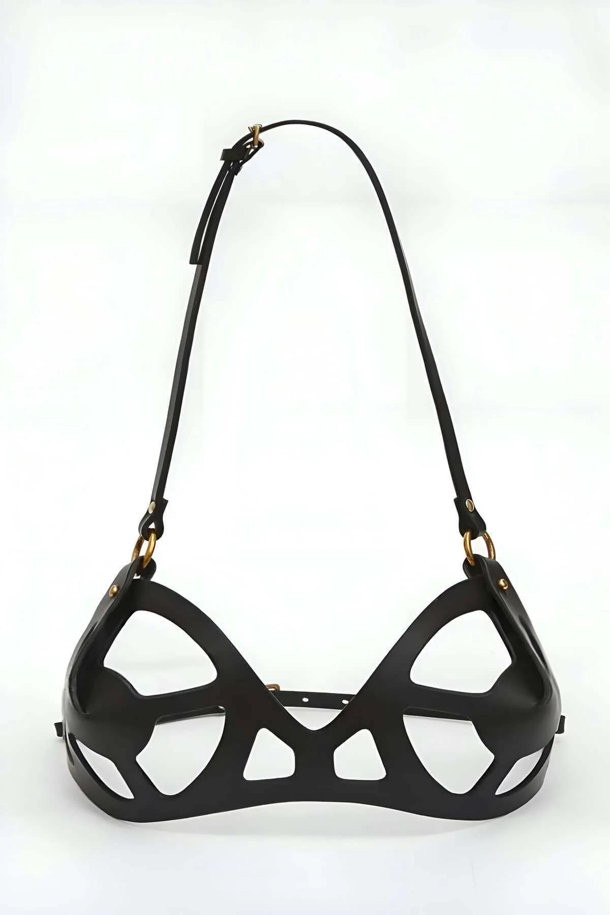 Black strappy harness bra detail shot highlighting silver O-ring shoulder hardware and glossy PU finish