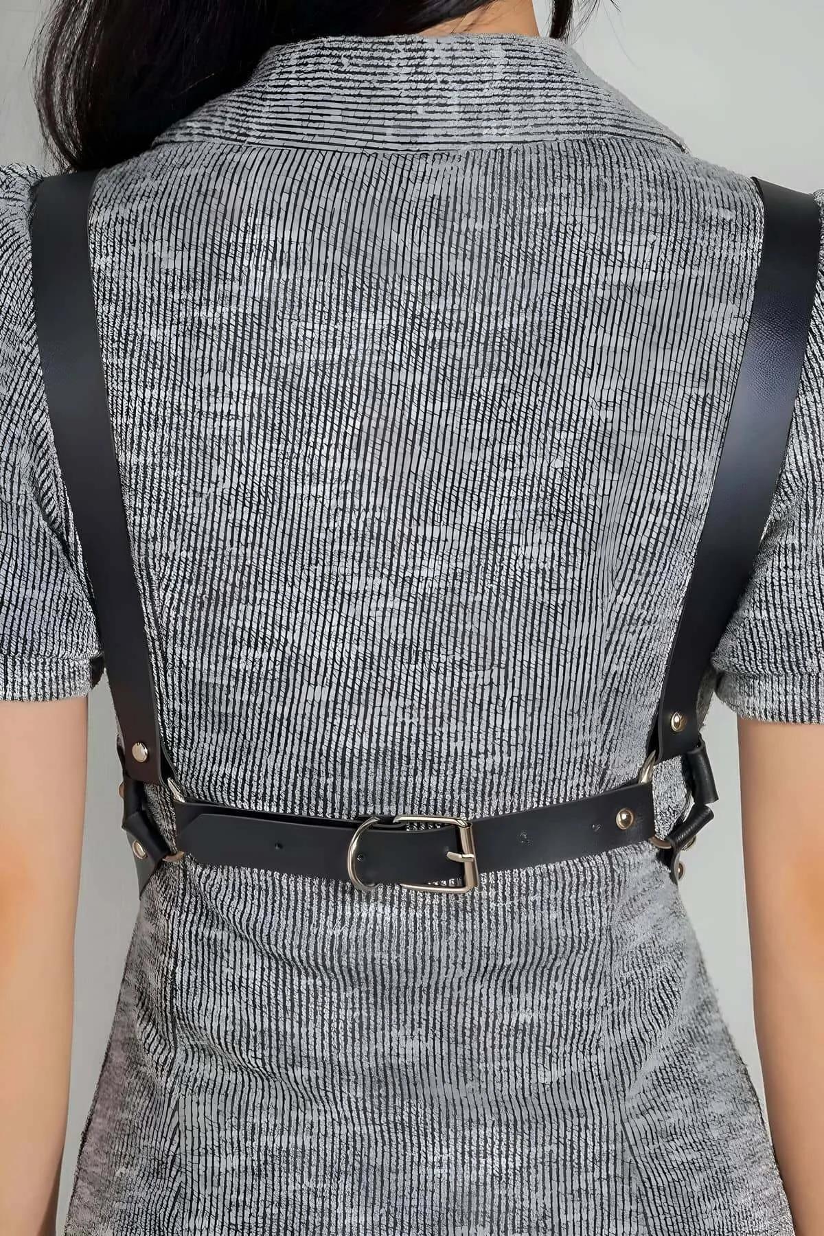 close-up of silver dome-head studs on black PU leather harness strap with O-ring detail