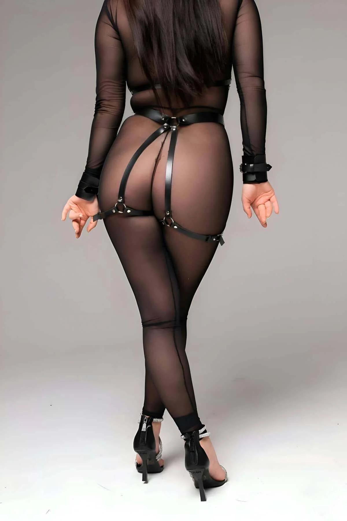 black faux leather chest harness with removable silver chain draped V-shape over torso close-up