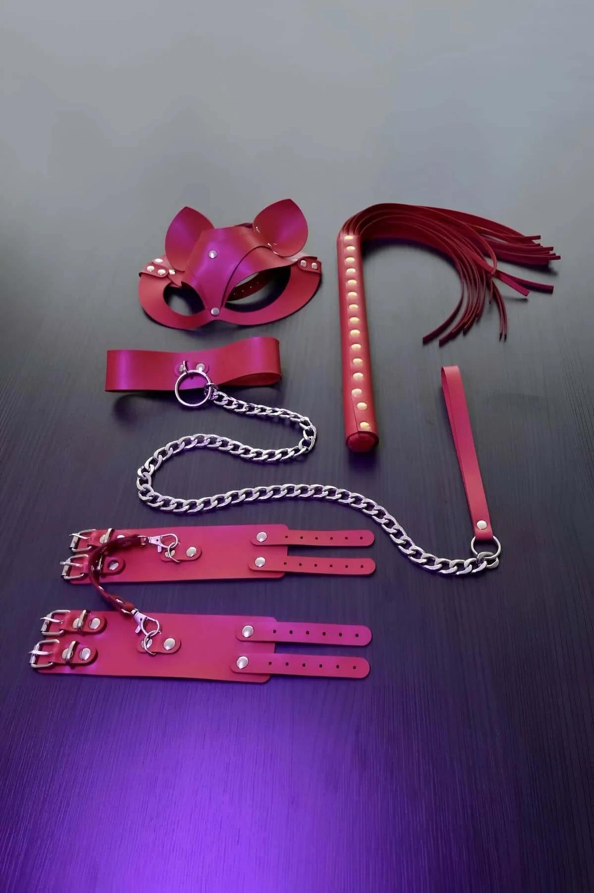 Close-up of red faux leather cat-ear eye mask with silver rivet trim and open eye cut-outs