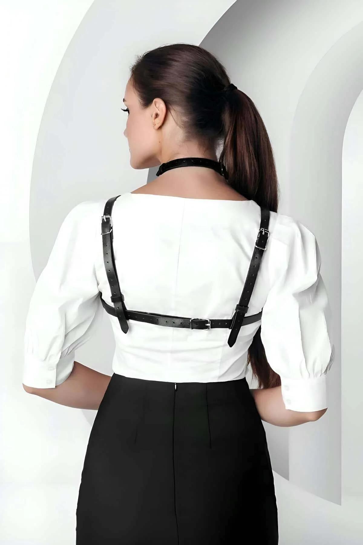 Black PU leather chest harness front view showing silver O-ring center detail and buckle closure