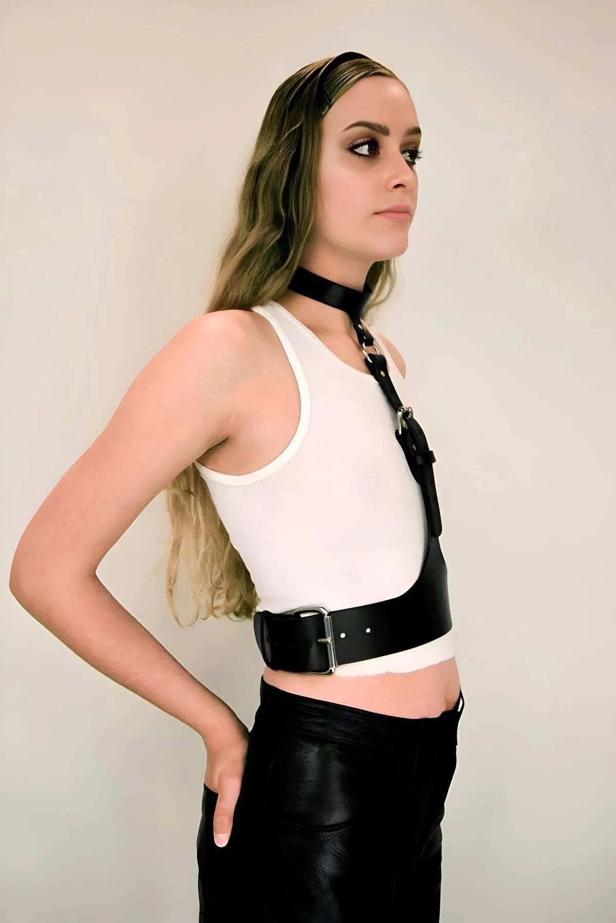 Close-up of silver rectangular buckle on black PU faux leather central chest strap