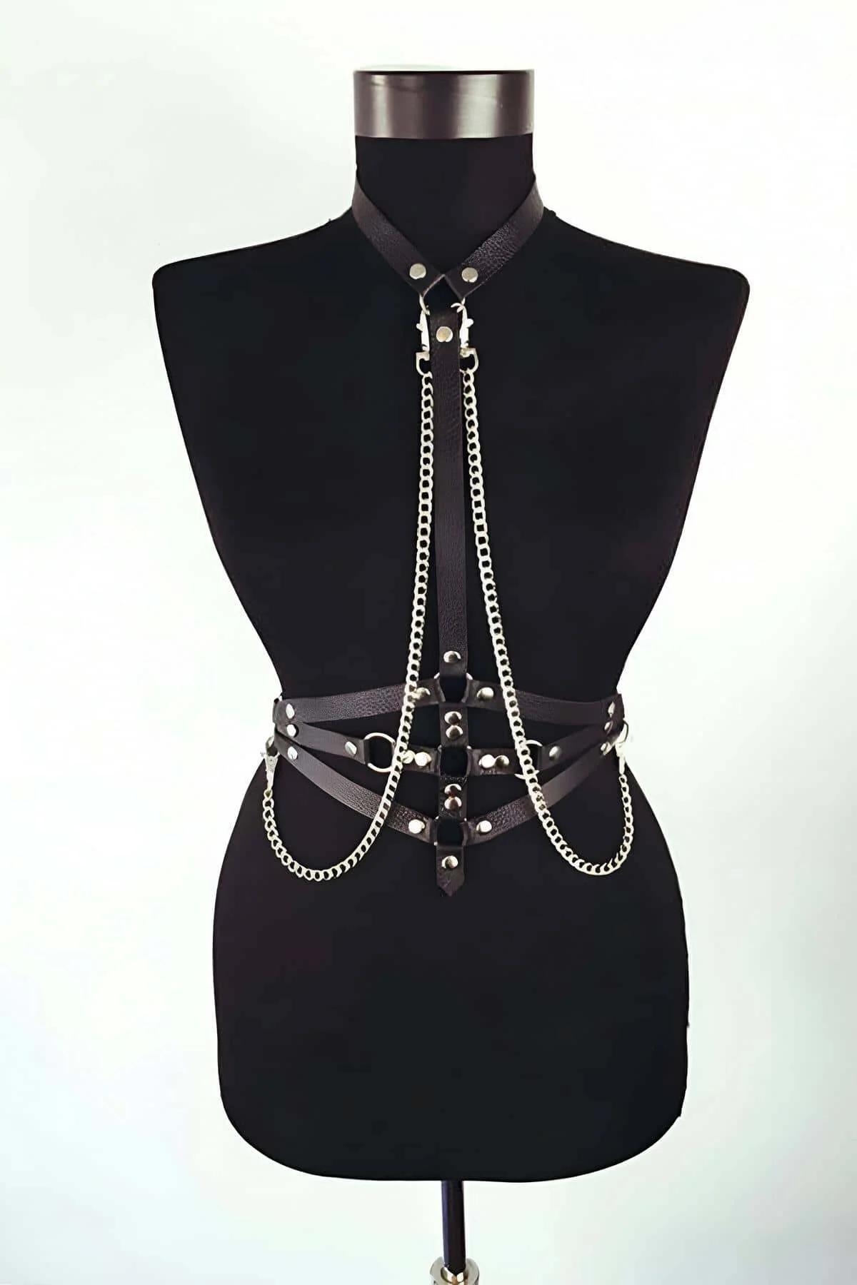 close-up of silver-tone curb chains and rivet studs on black faux leather chest harness straps