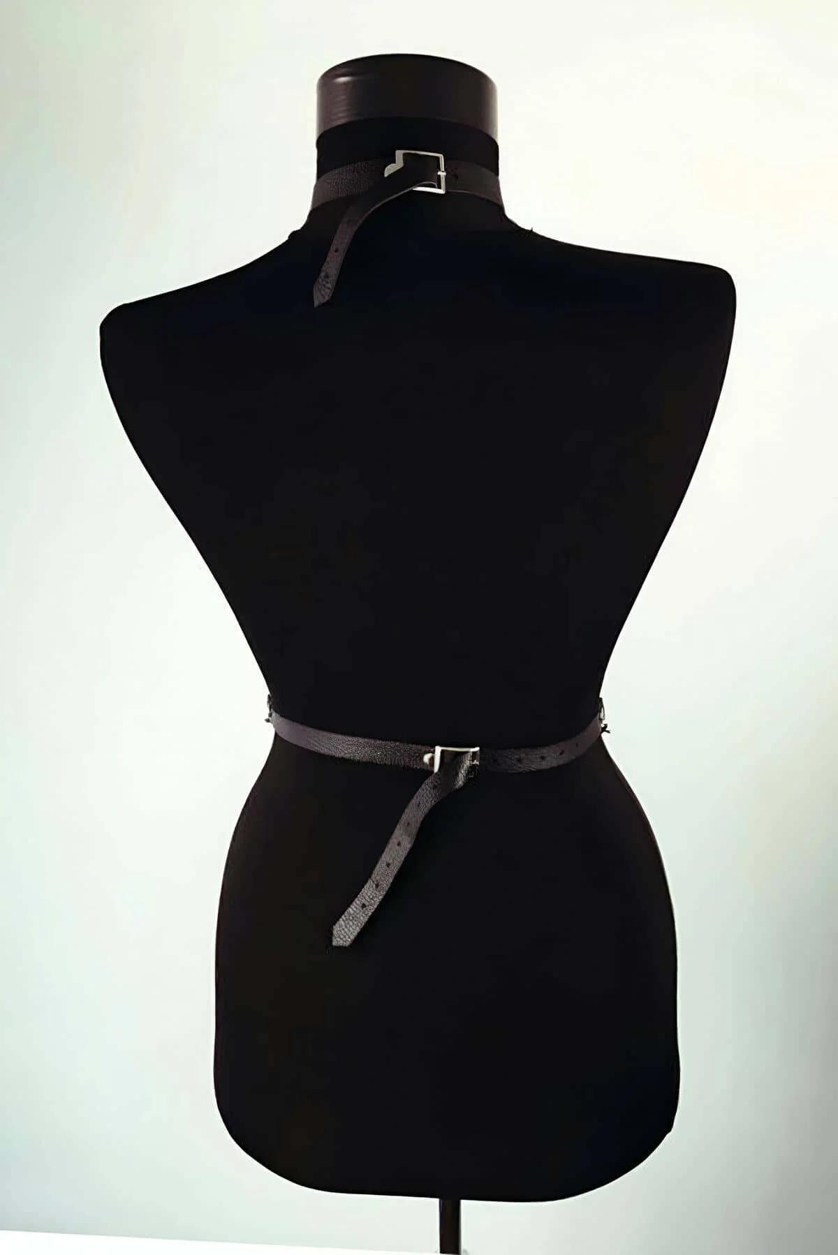 black PU leather harness waist belt with silver O-rings and draped chain detail on dress form