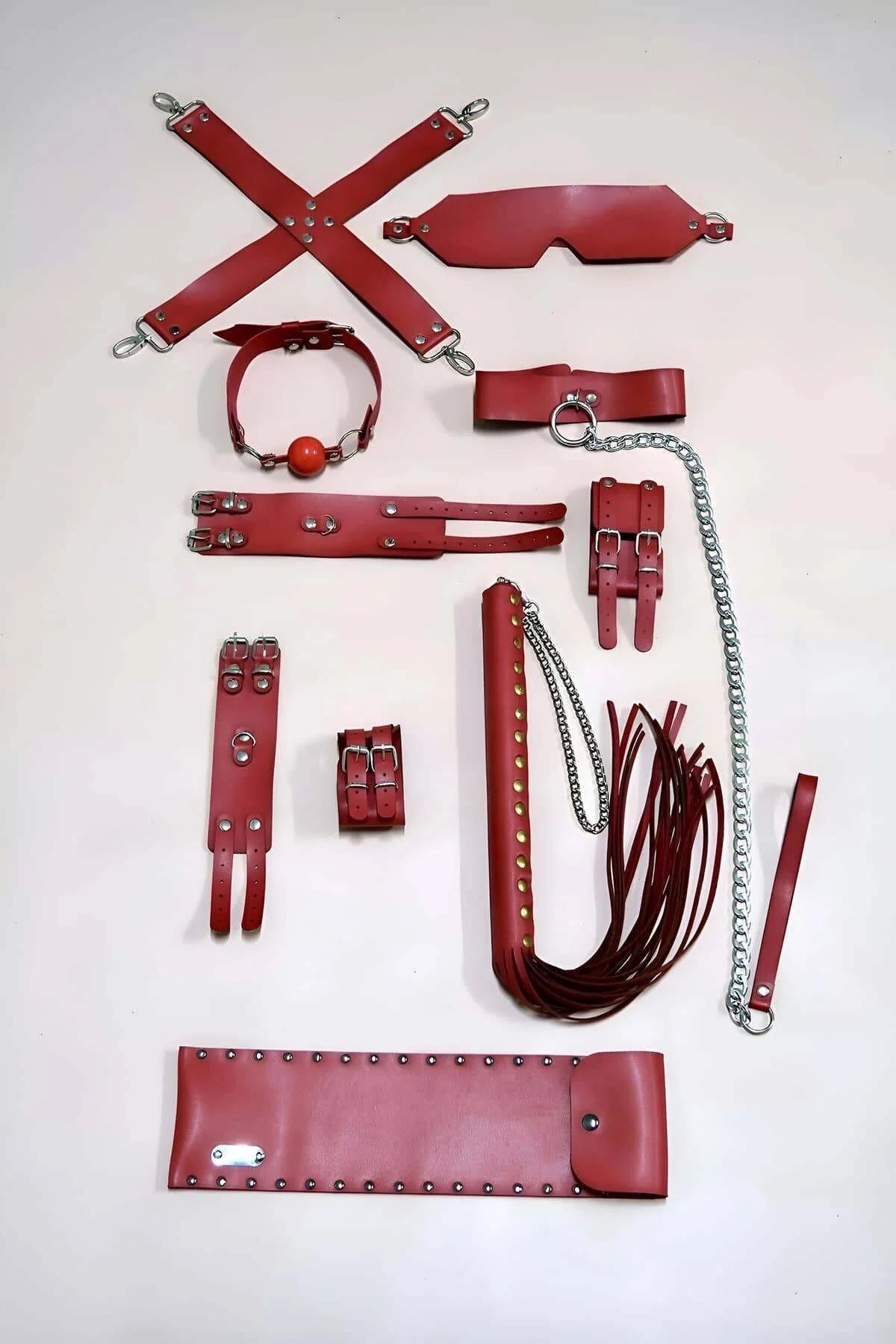 Red PU leather hogtie cross-strap with four silver swivel clips on white background