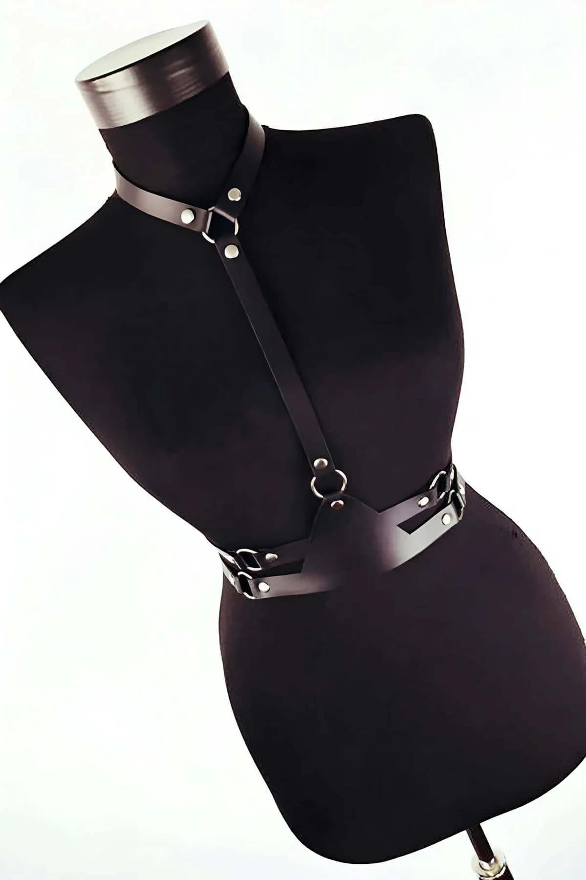 Close-up of silver O-ring and rivet hardware on black PU leather chest harness center strap