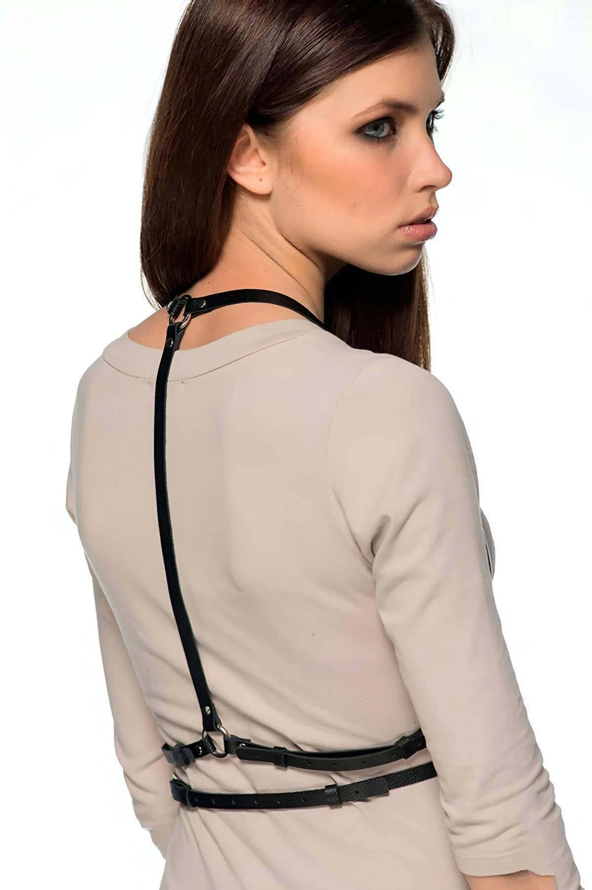 Close-up of silver zinc-alloy O-ring hardware on black PU leather chest harness straps
