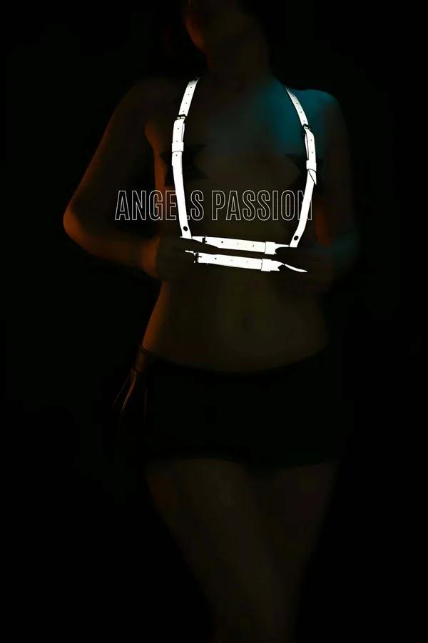 White reflective chest harness with wide adjustable nylon straps glowing against dark background, Y-shaped bib configuration