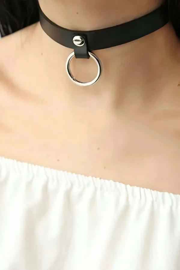 Black faux leather wide band choker necklace with silver O-ring pendant on neck