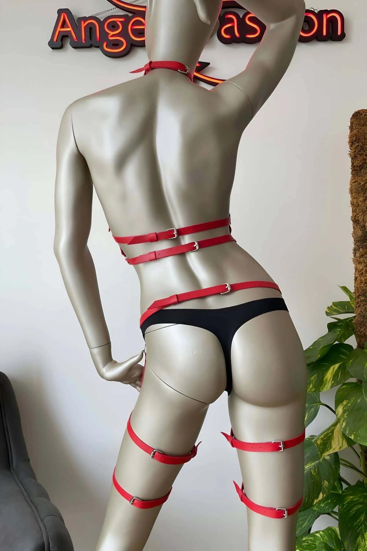 Close-up of red PU leather strap junction with silver O-ring and stud rivets on body harness