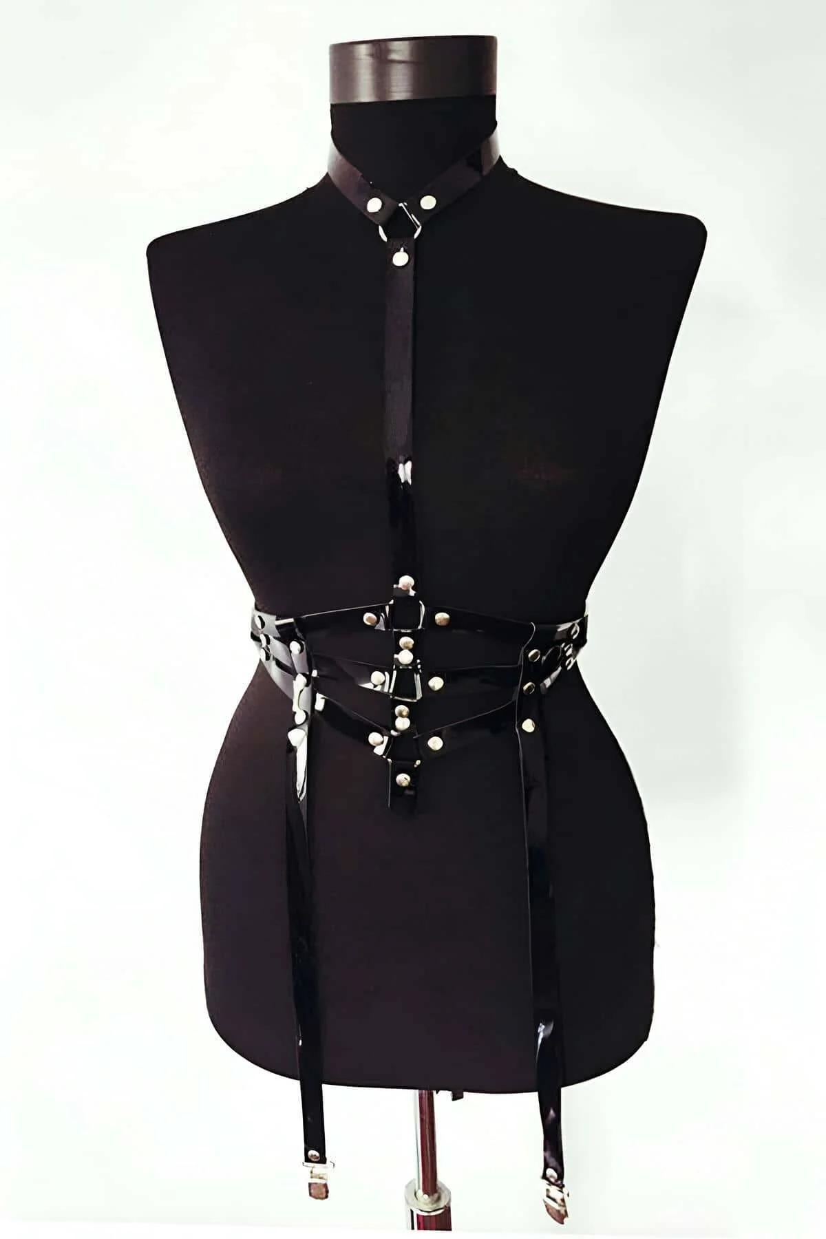 black glossy faux leather body harness with structured waist cage, collar strap, and four silver garter clip straps on manneq