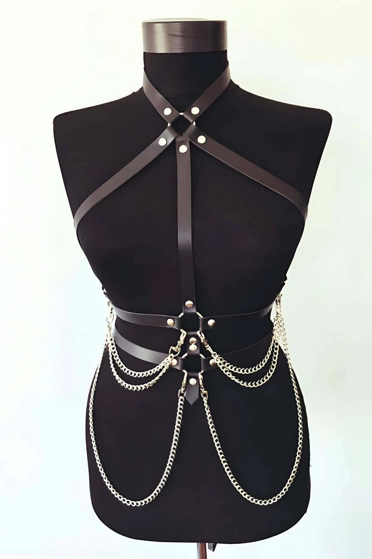 Black faux leather strappy body harness with three cascading gold-tone chain rows draped across the waist on a mannequin