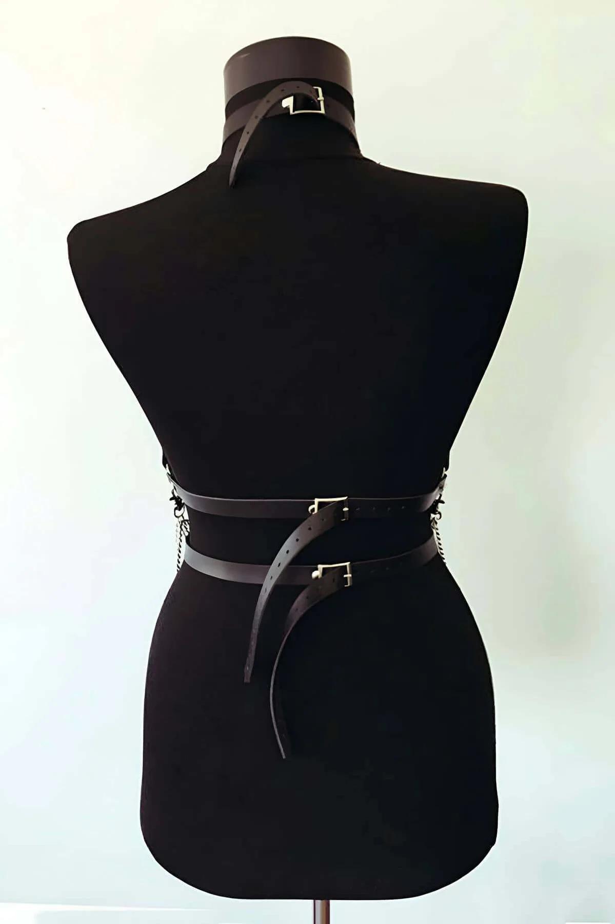 Cross-front chest strap detail with silver rivet studs on black PU leather harness