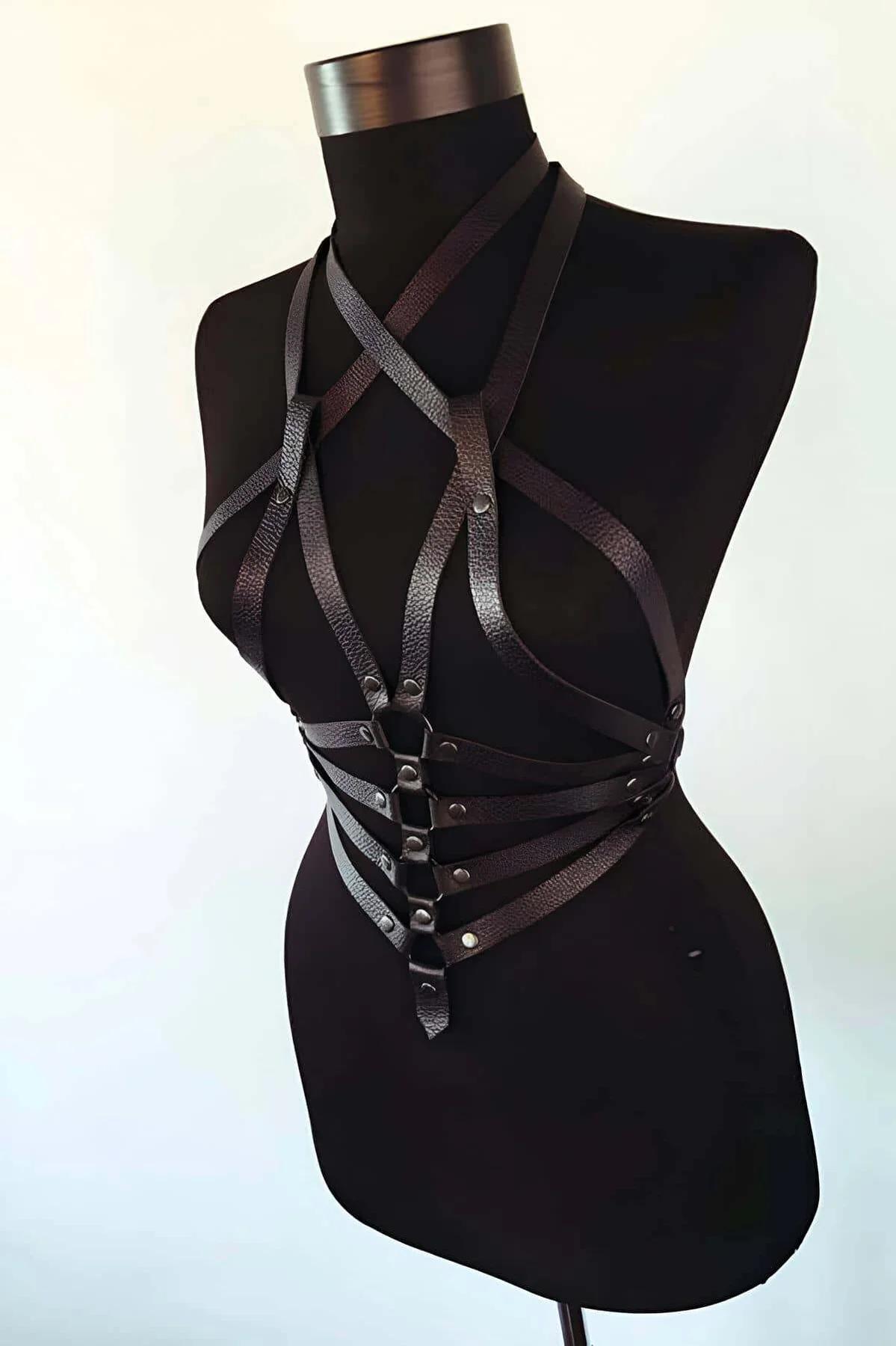 Close-up of triple O-ring centerpiece with antique bronze riveted studs on black faux leather harness
