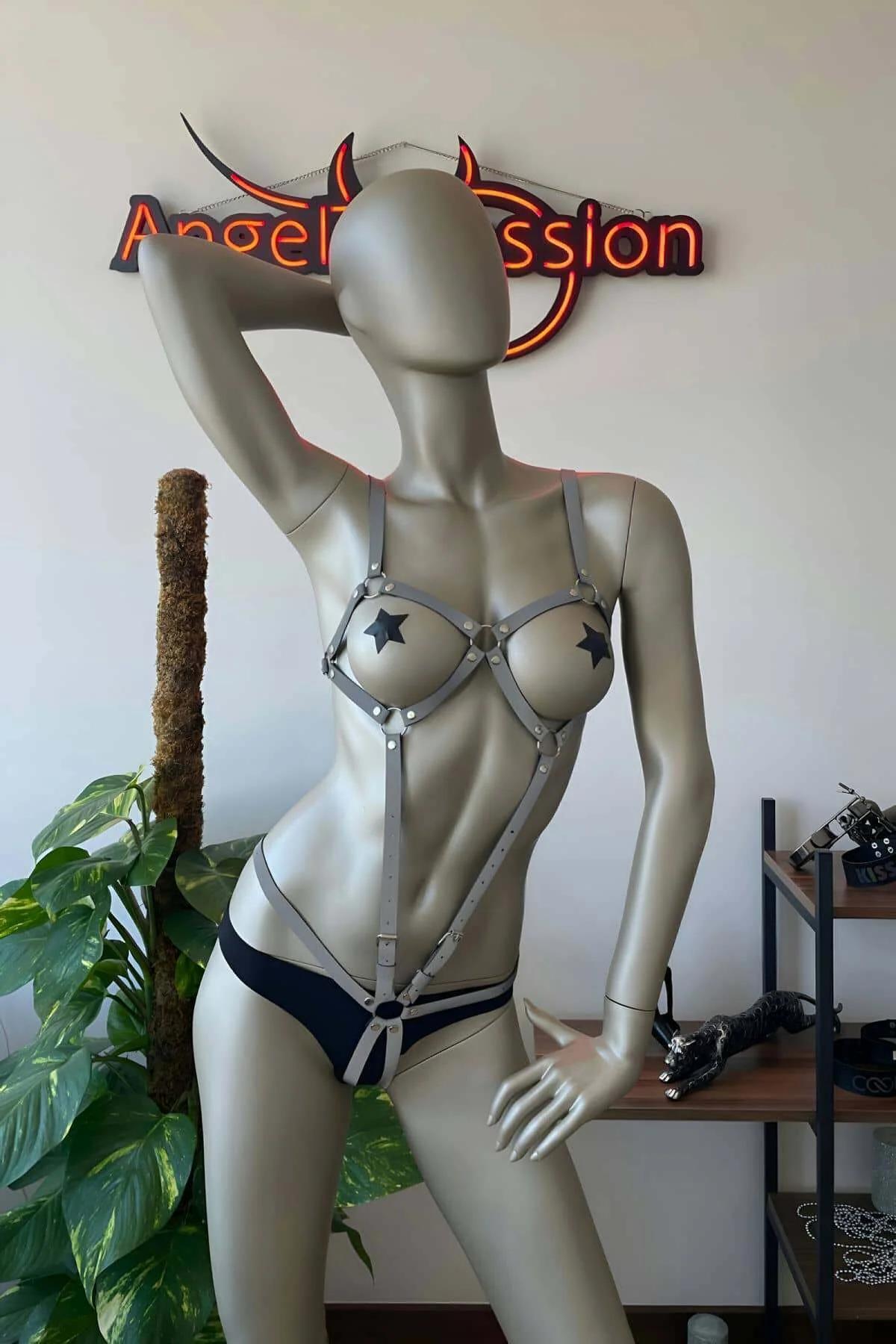 White reflective strap harness worn over black bodysuit showing geometric hip and waist strap layout