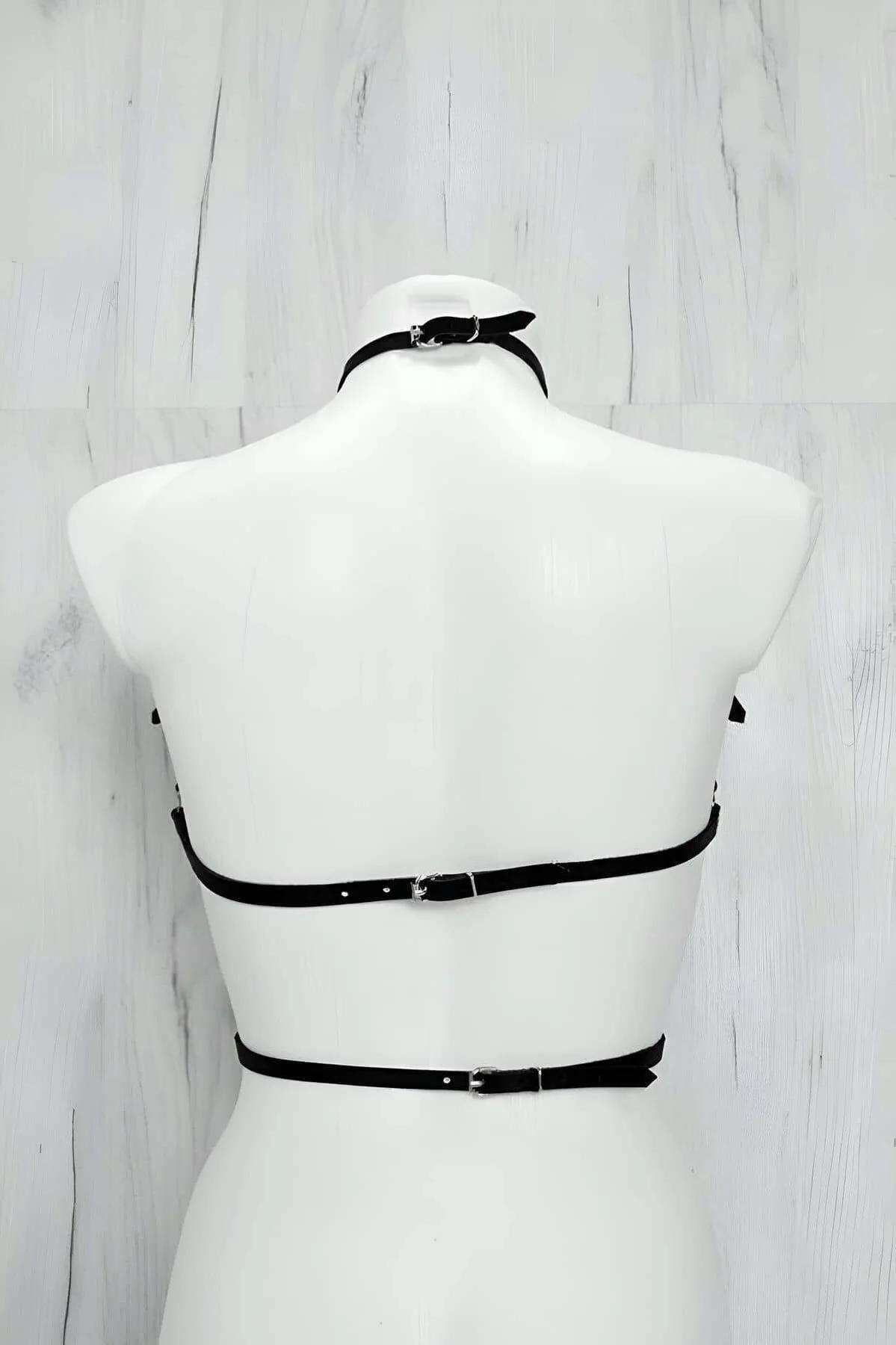 Close-up of silver O-ring choker collar attached to black faux leather chest harness