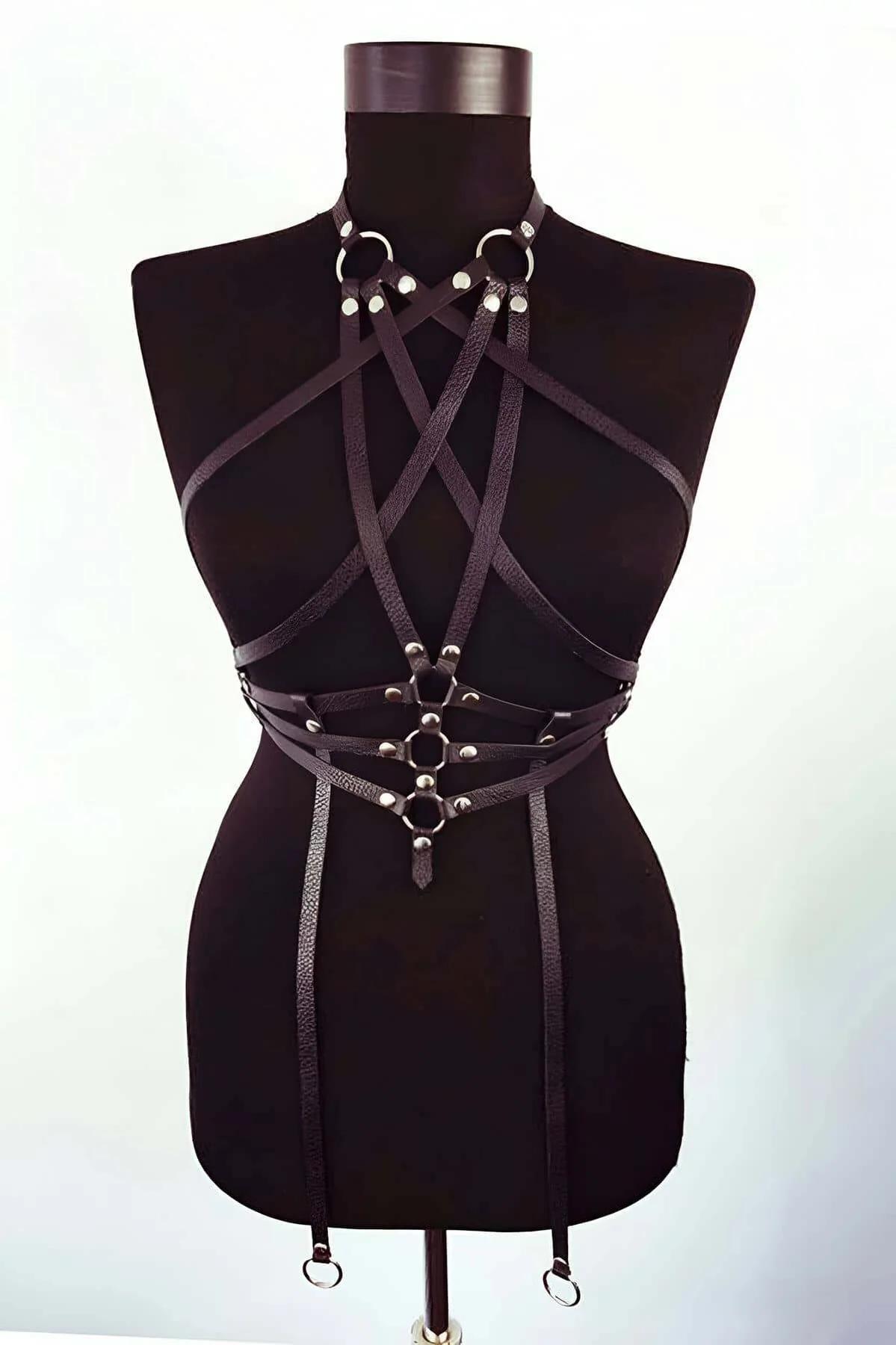 Close-up of silver-tone O-ring waist cluster and rivet studs on black faux leather body harness