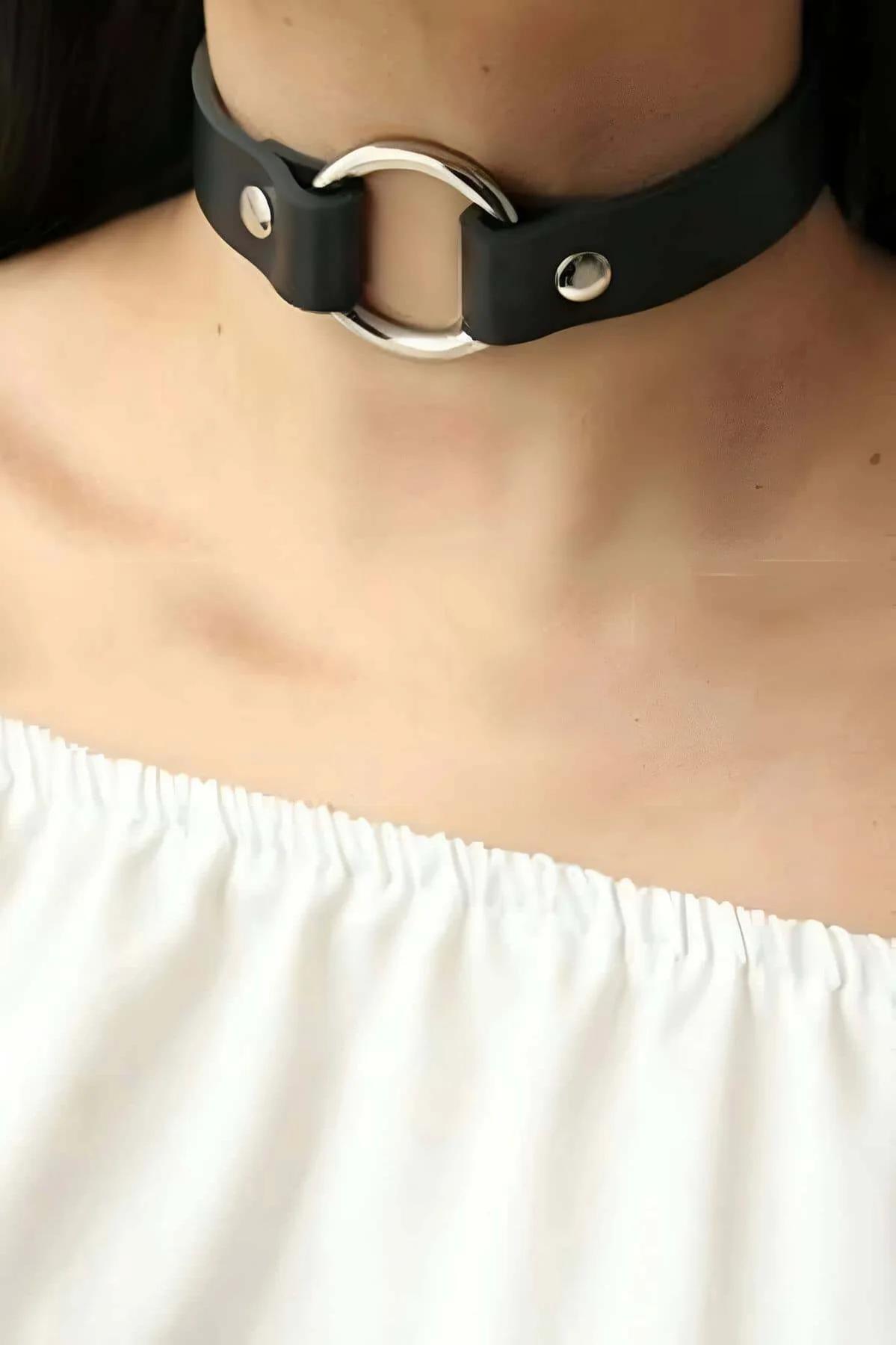 Close-up of silver O-ring rivet hardware on slim black faux leather choker band